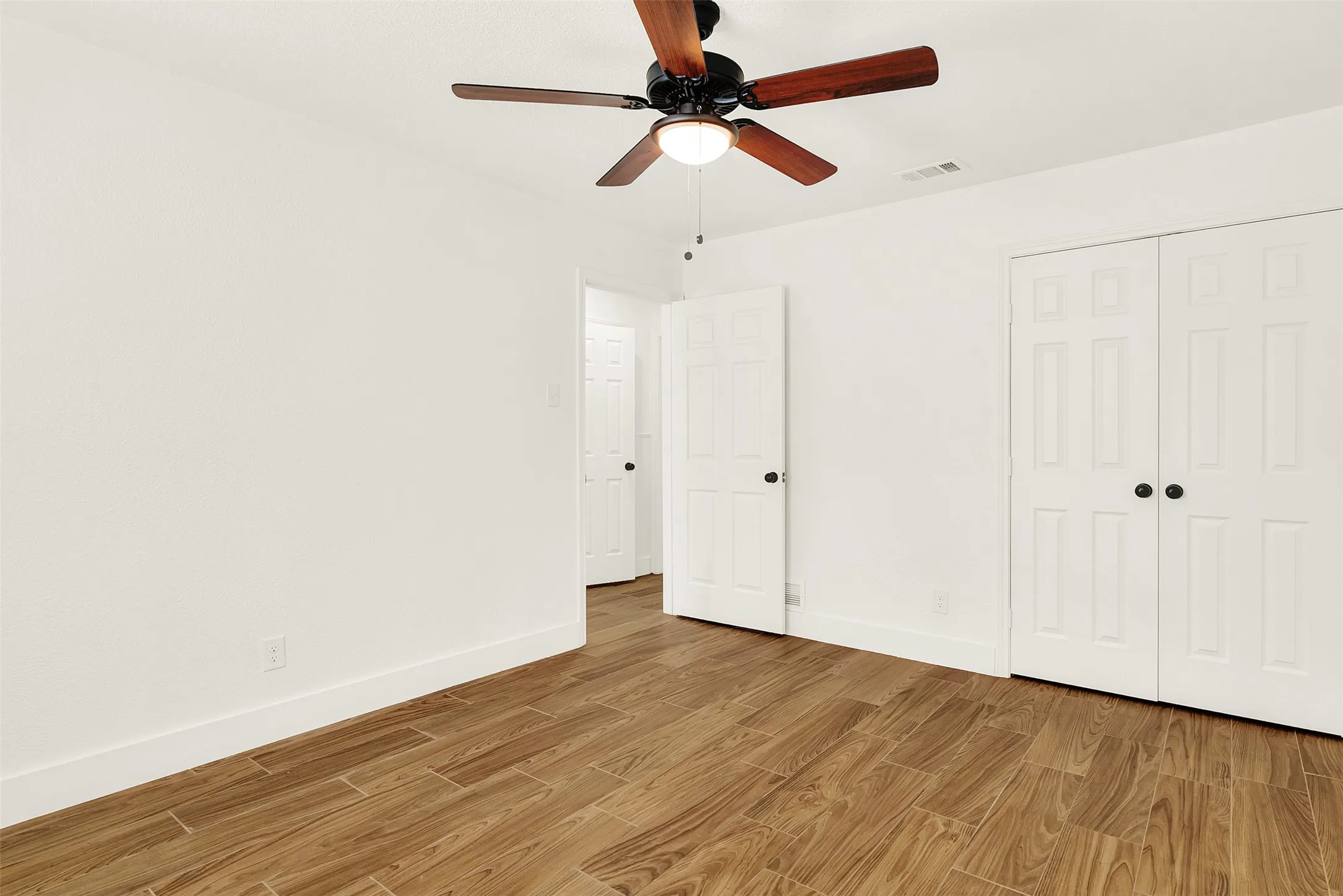 Unfurnished bedroom featuring light wood-style flooring, a closet, and ceiling fan