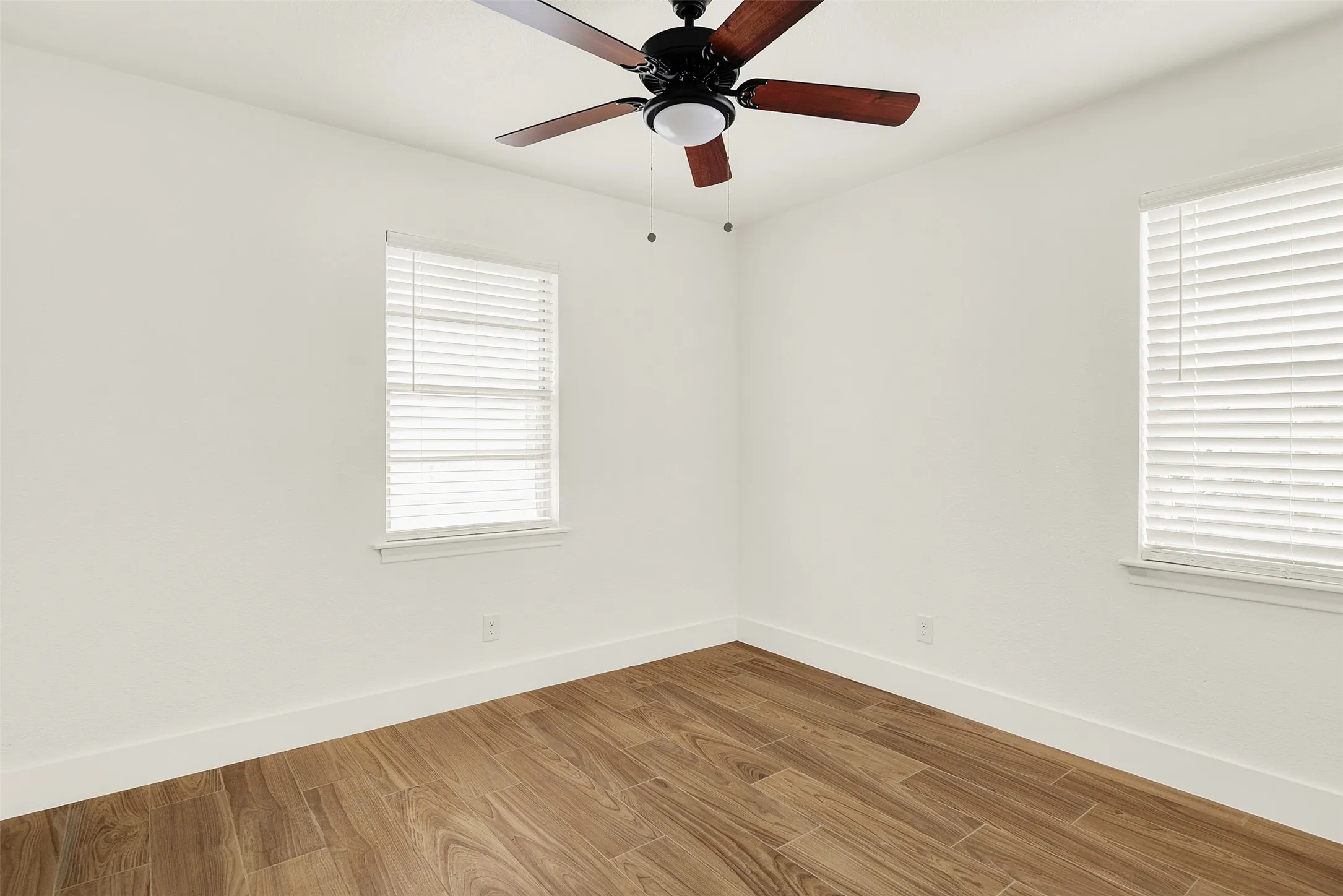 Unfurnished room with light wood-type flooring and a ceiling fan