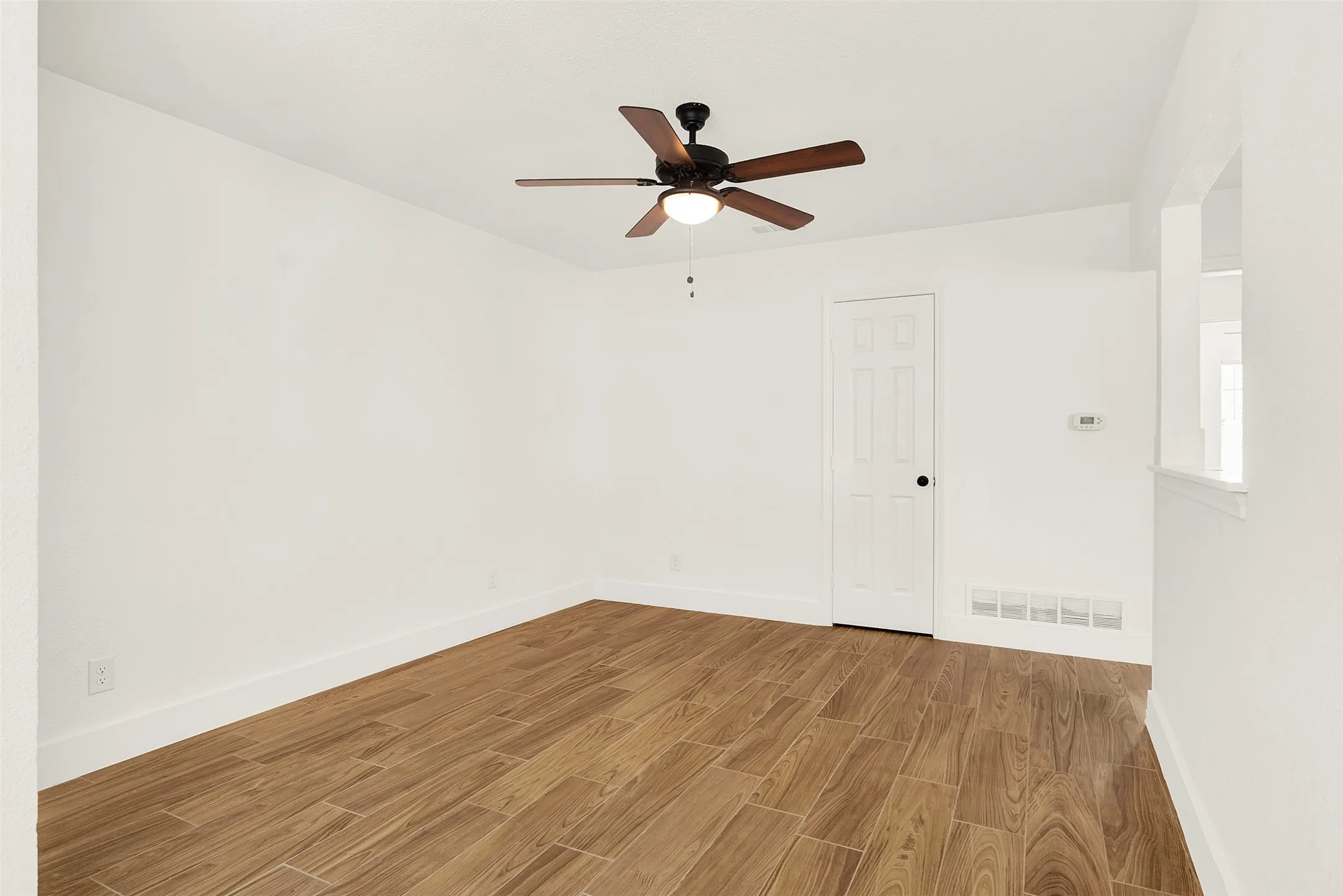 Spare room with wood finished floors and ceiling fan