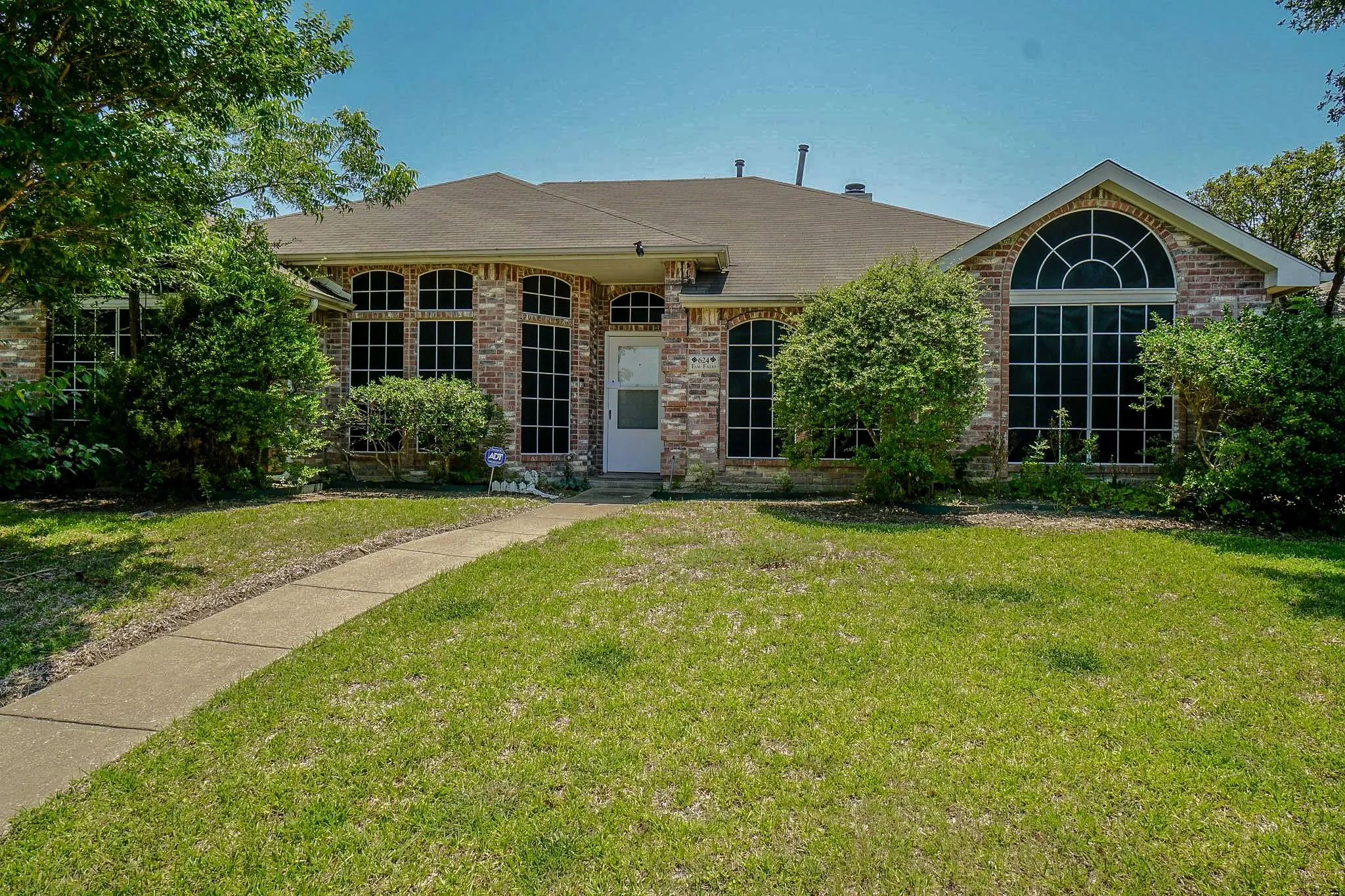 Brick exterior with multiple arched windows and a prominent arched transom window