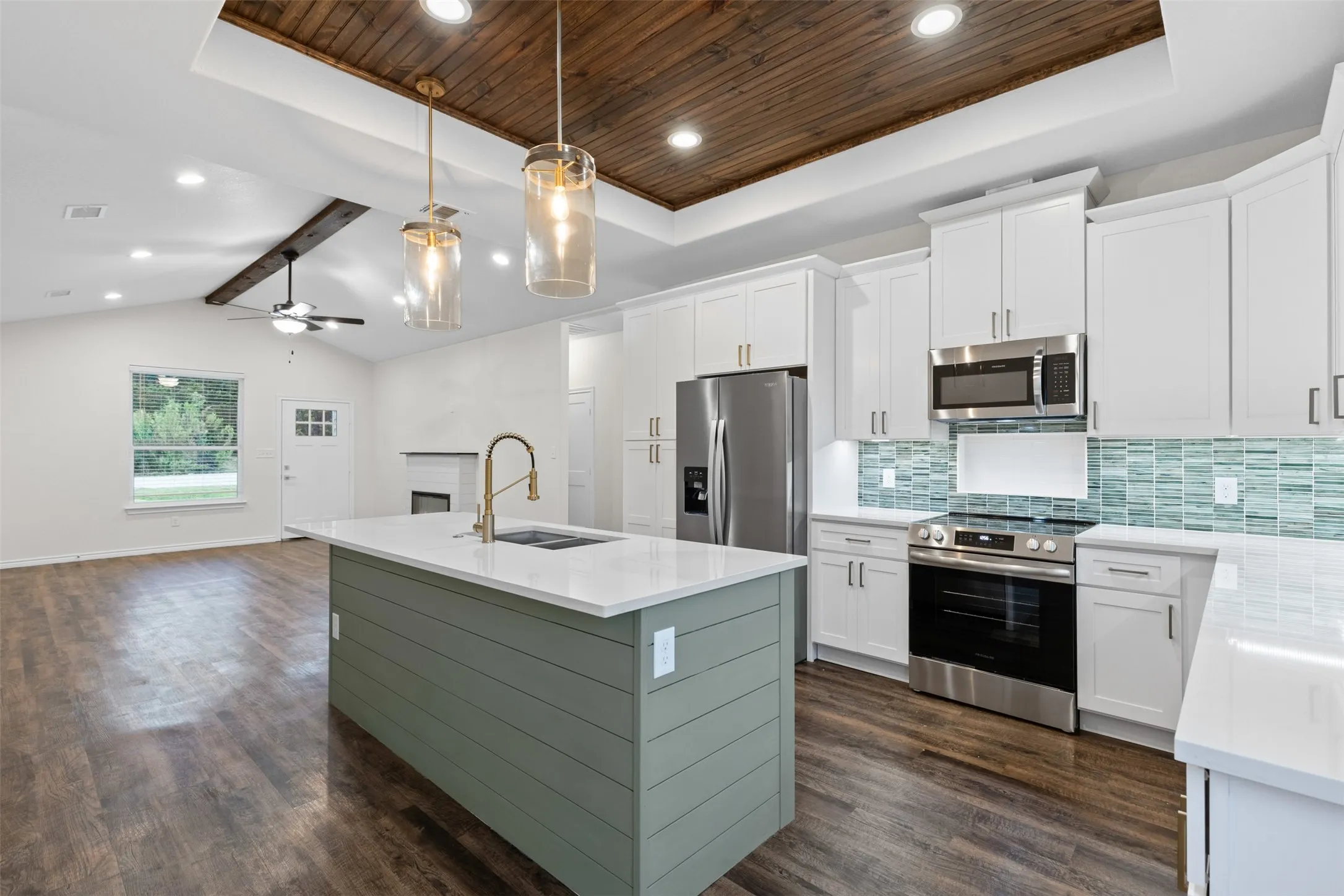 Kitchen with stainless steel appliances, a sink, wood ceiling, dark wood-type flooring, and backsplash