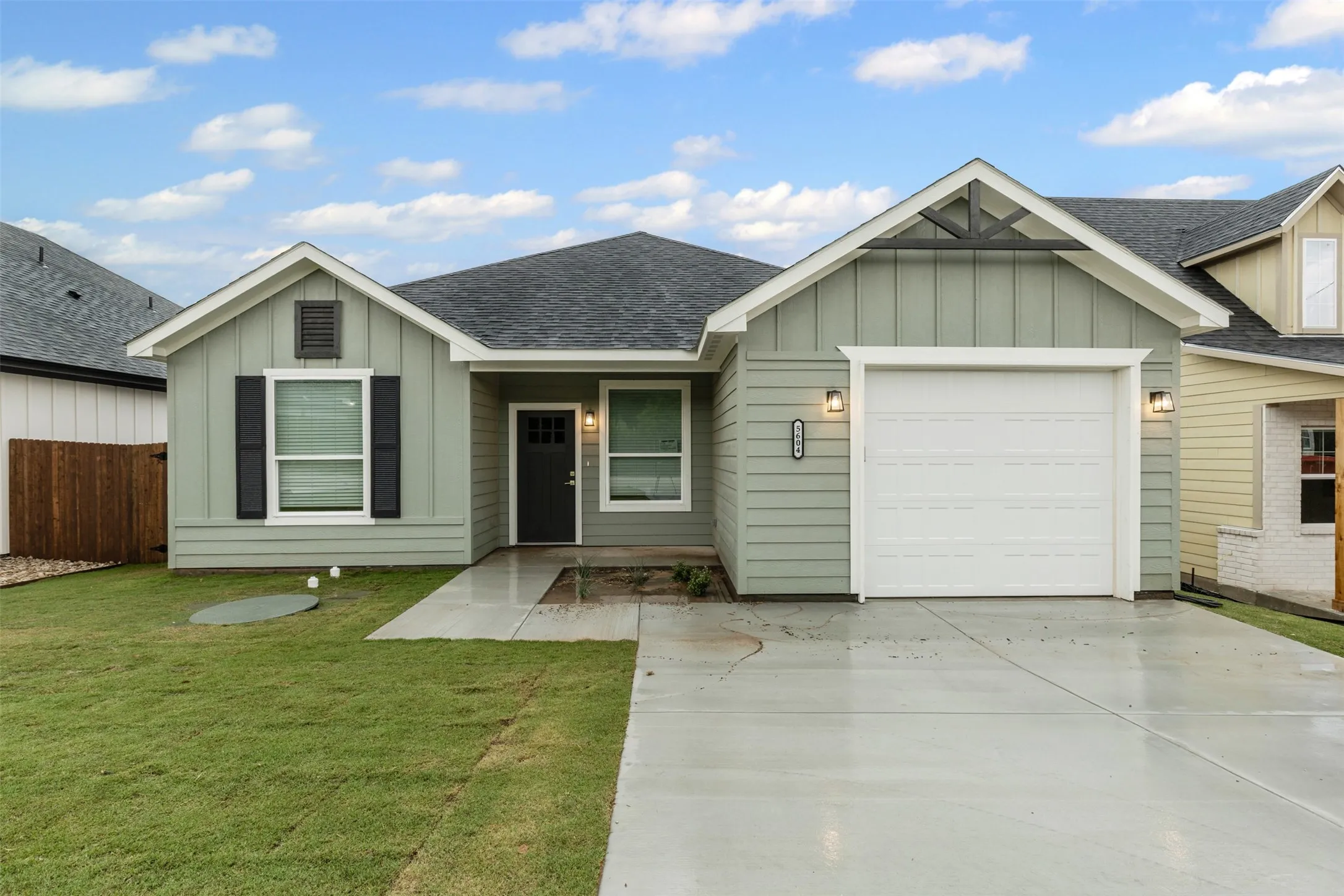 Ranch-style house featuring board and batten siding, a shingled roof, and a garage