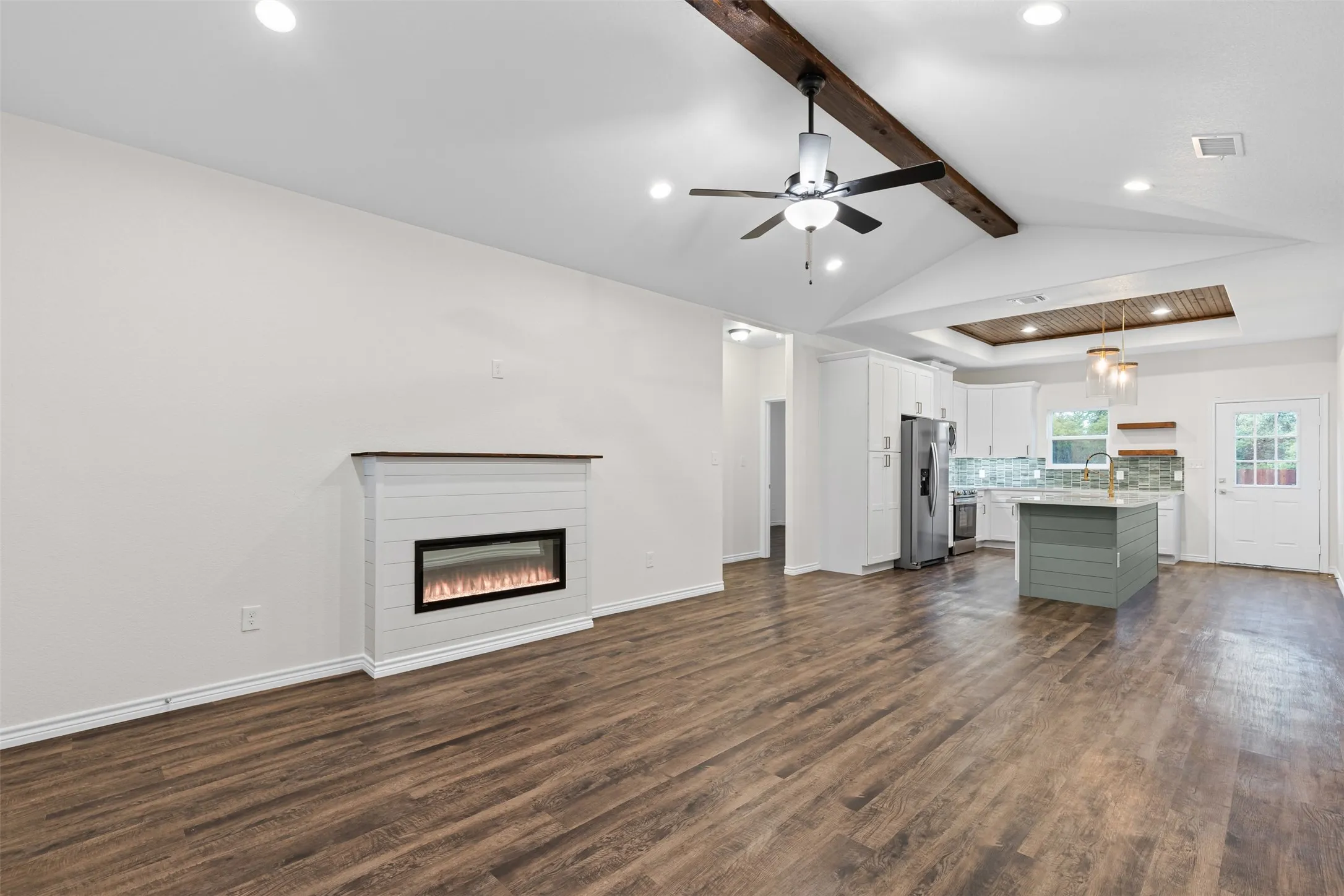Unfurnished living room featuring recessed lighting, dark wood-style flooring, a glass covered fireplace, ceiling fan, and baseboards