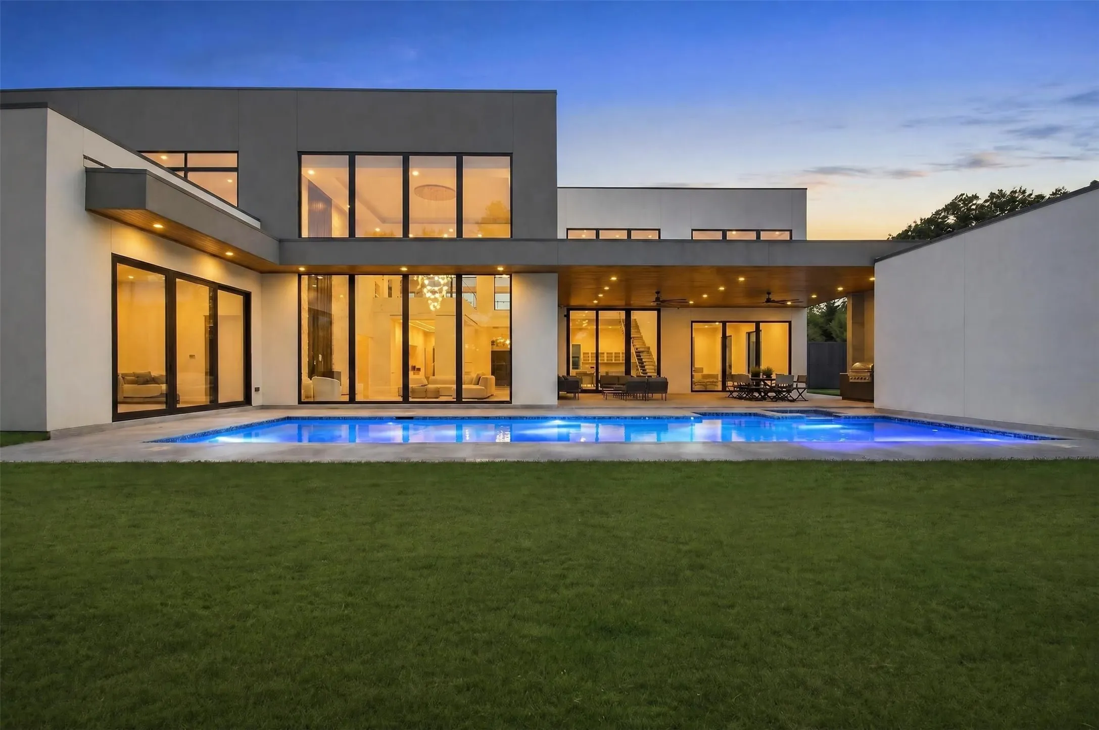 Modern exterior with expansive windows, a rectangular swimming pool, a spacious patio, and a covered outdoor living area