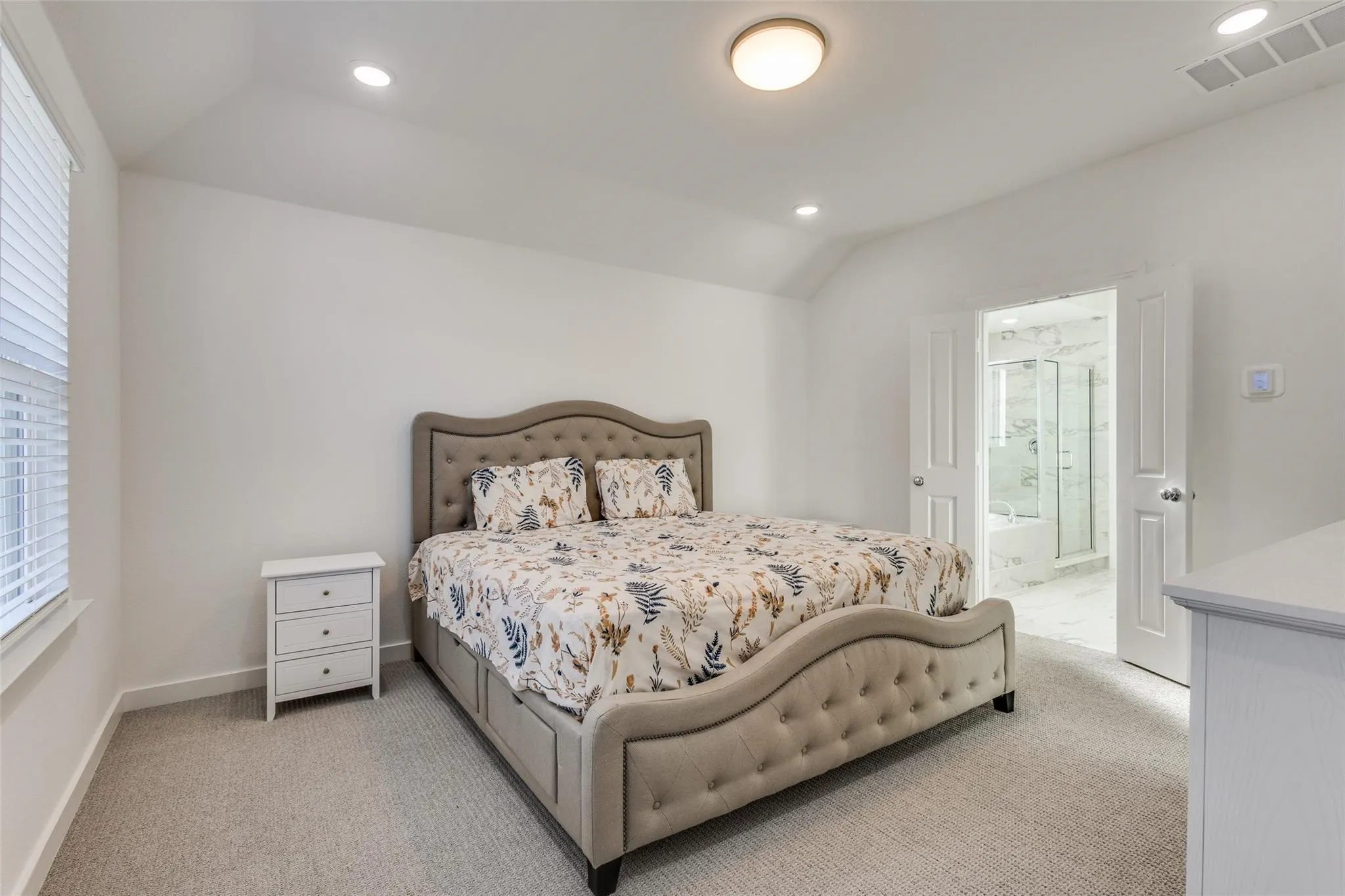 Carpeted room with vaulted ceiling and recessed lighting
