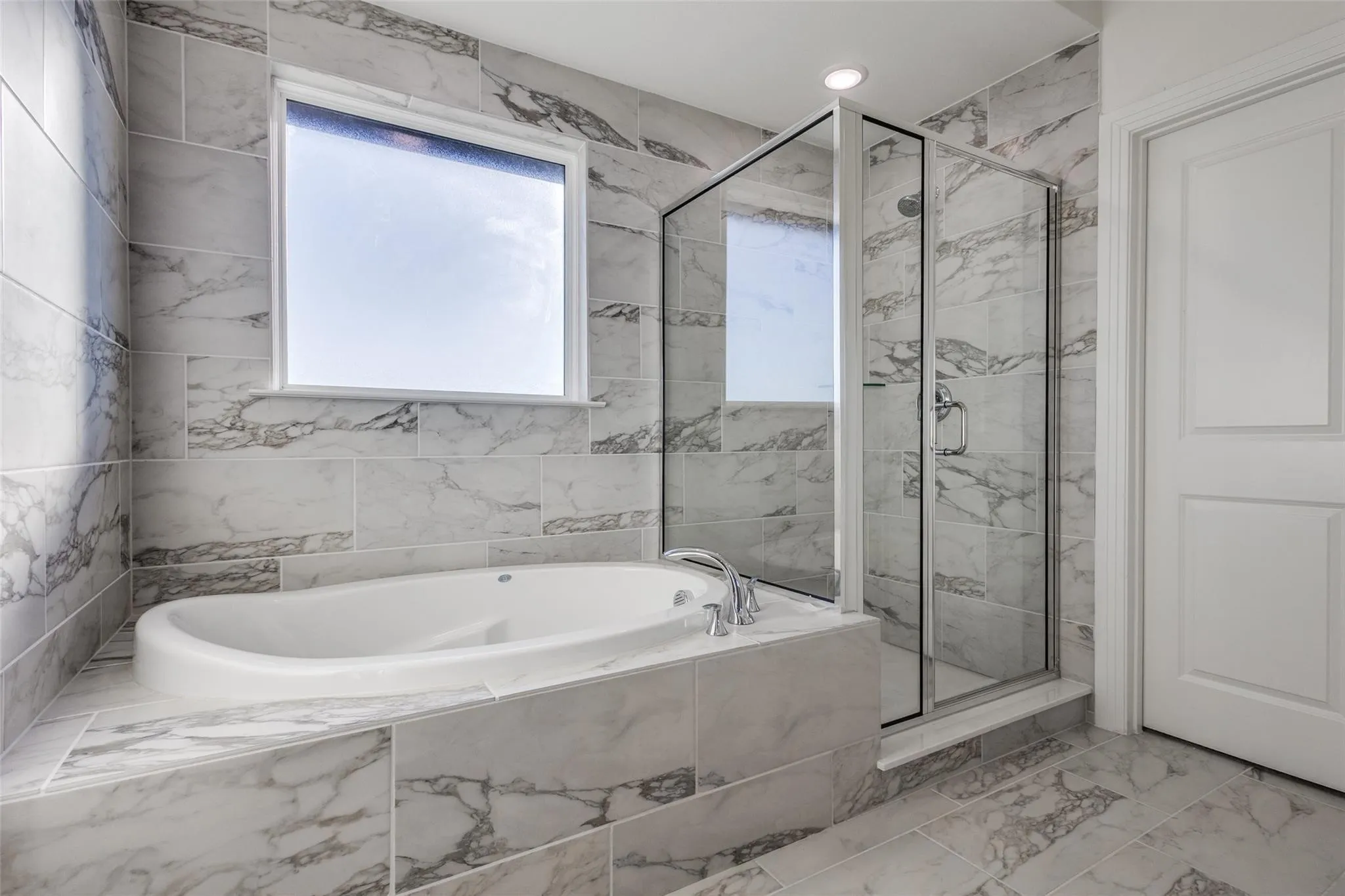 Recessed lighting illuminates the tiled walls and flooring