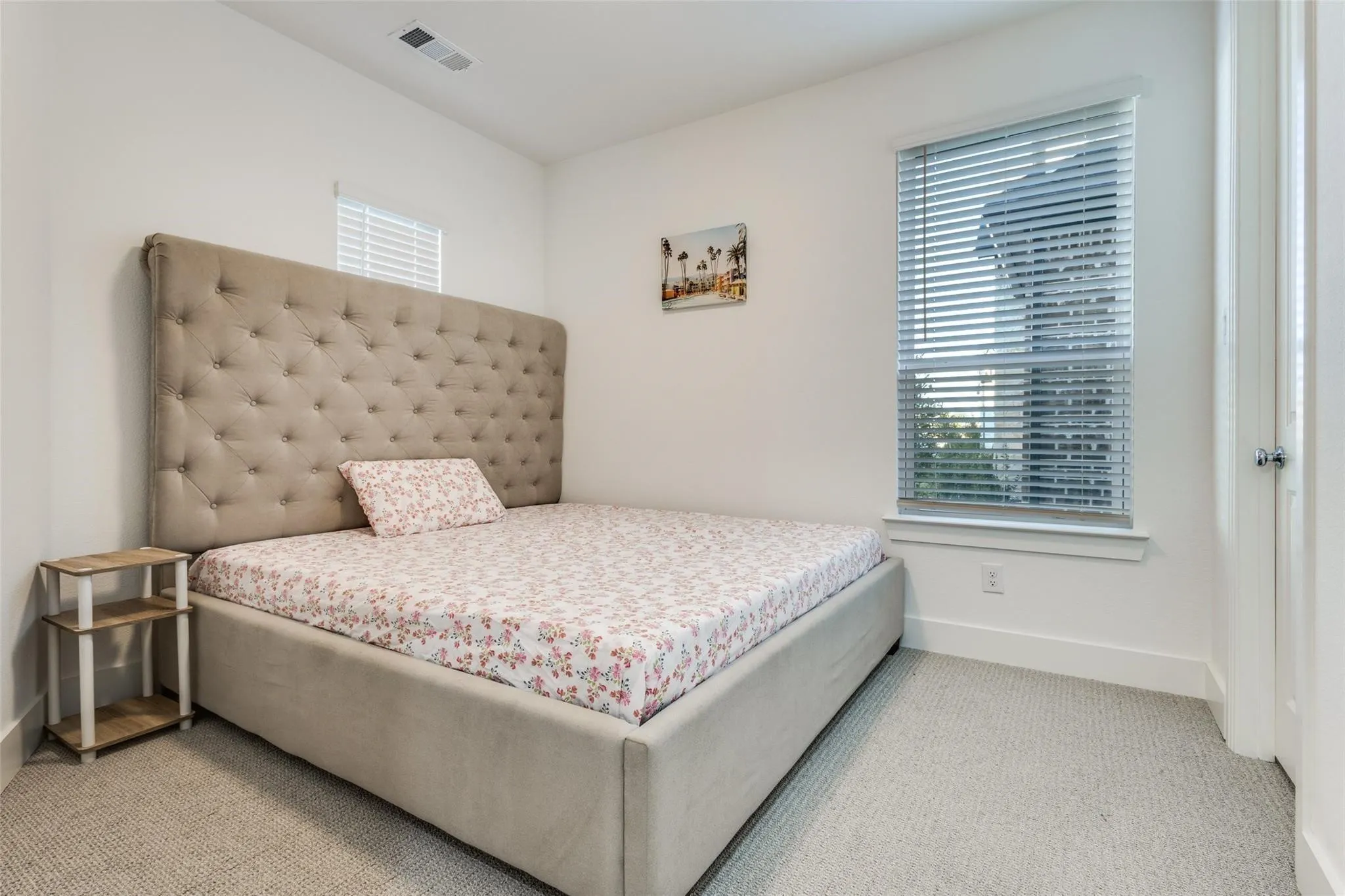 Neutral wall color, carpeted flooring, window with blinds, and white trim