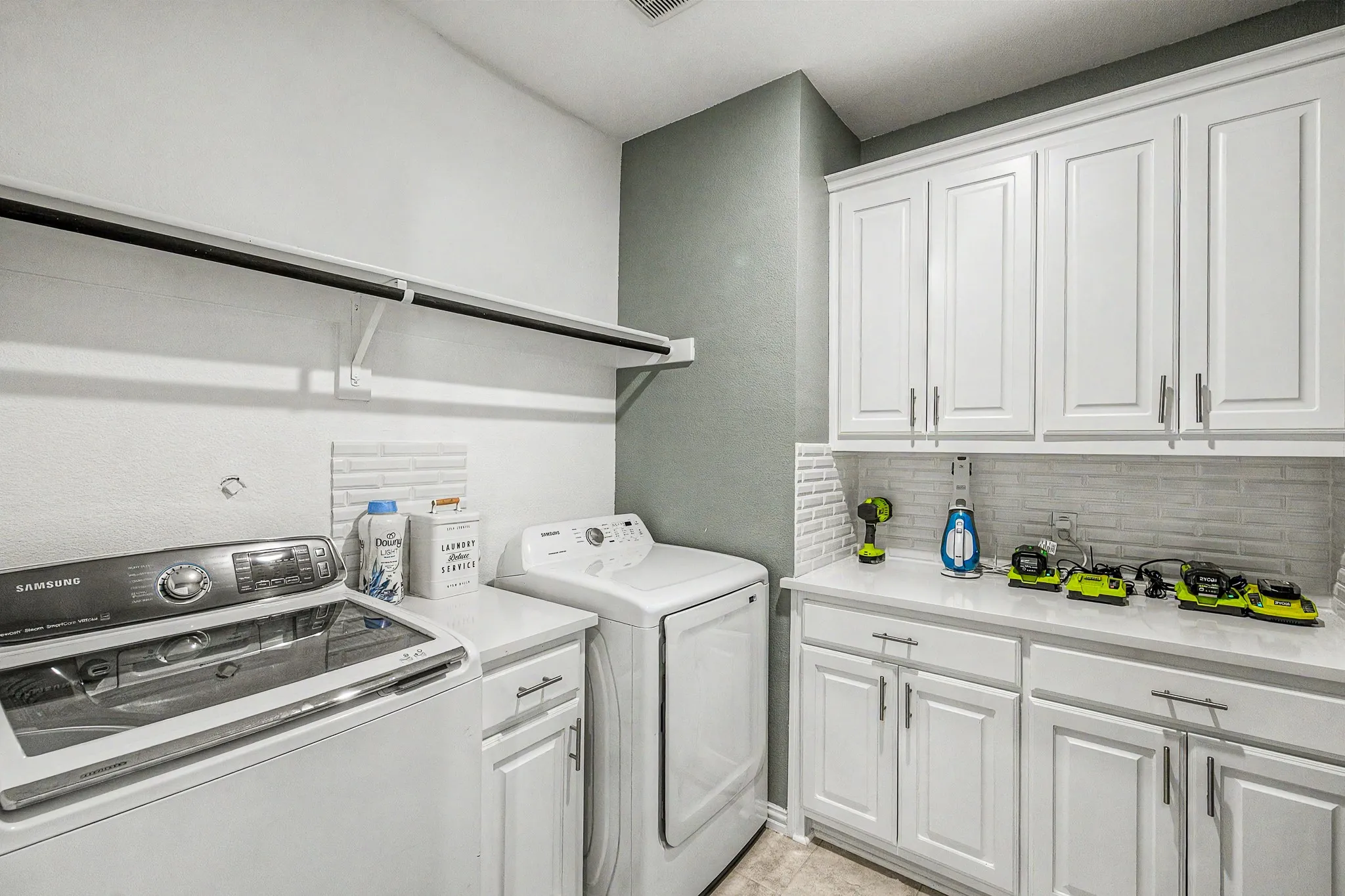 Built-in cabinetry, white countertops, subway tile backsplash, and a drying​​‌​​​​‌​​‌‌​‌‌​​​‌‌​‌​‌​‌​​​‌​​ rack