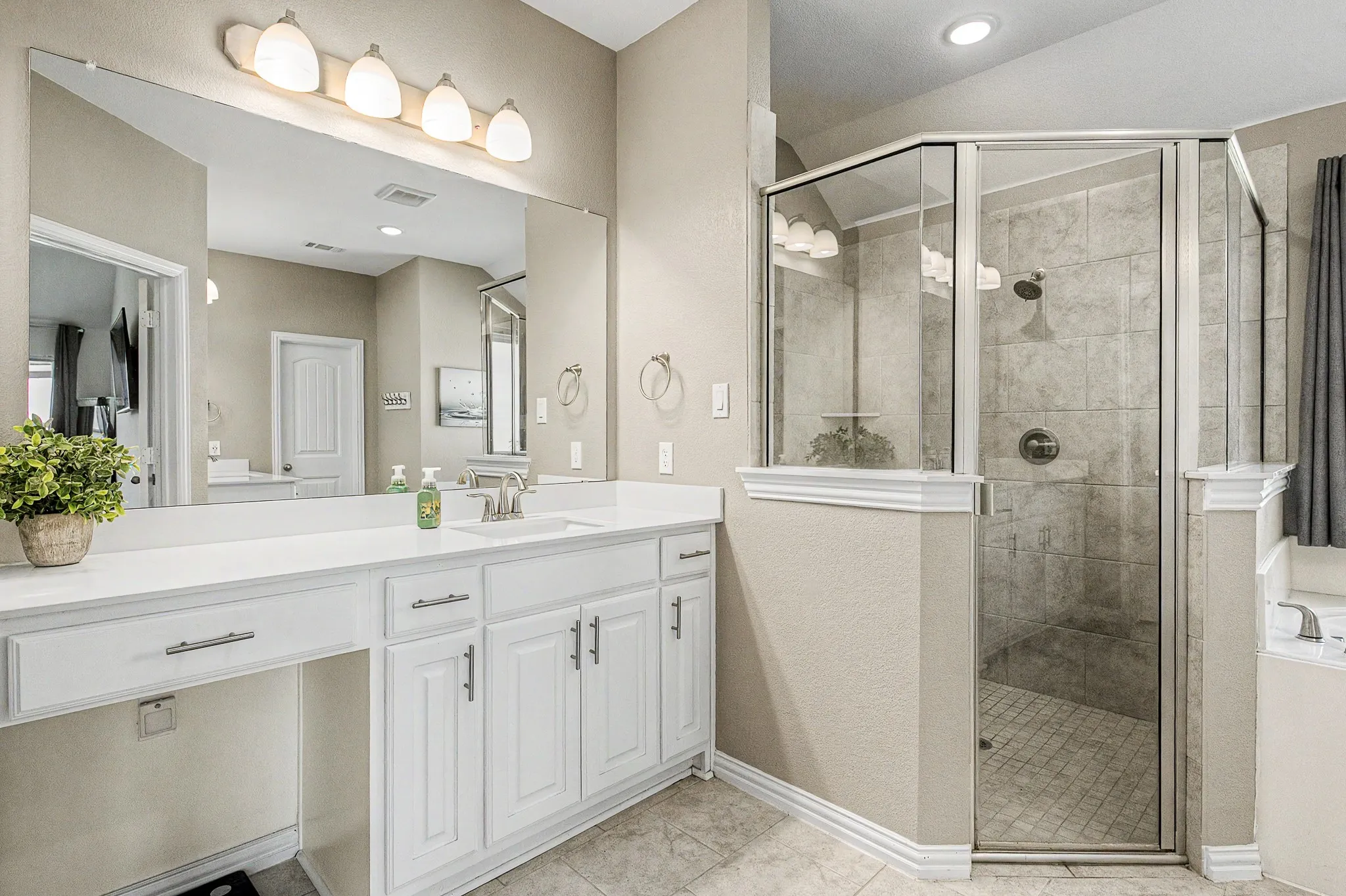 Double vanity with white cabinetry, a single undermount sink, and a makeup counter