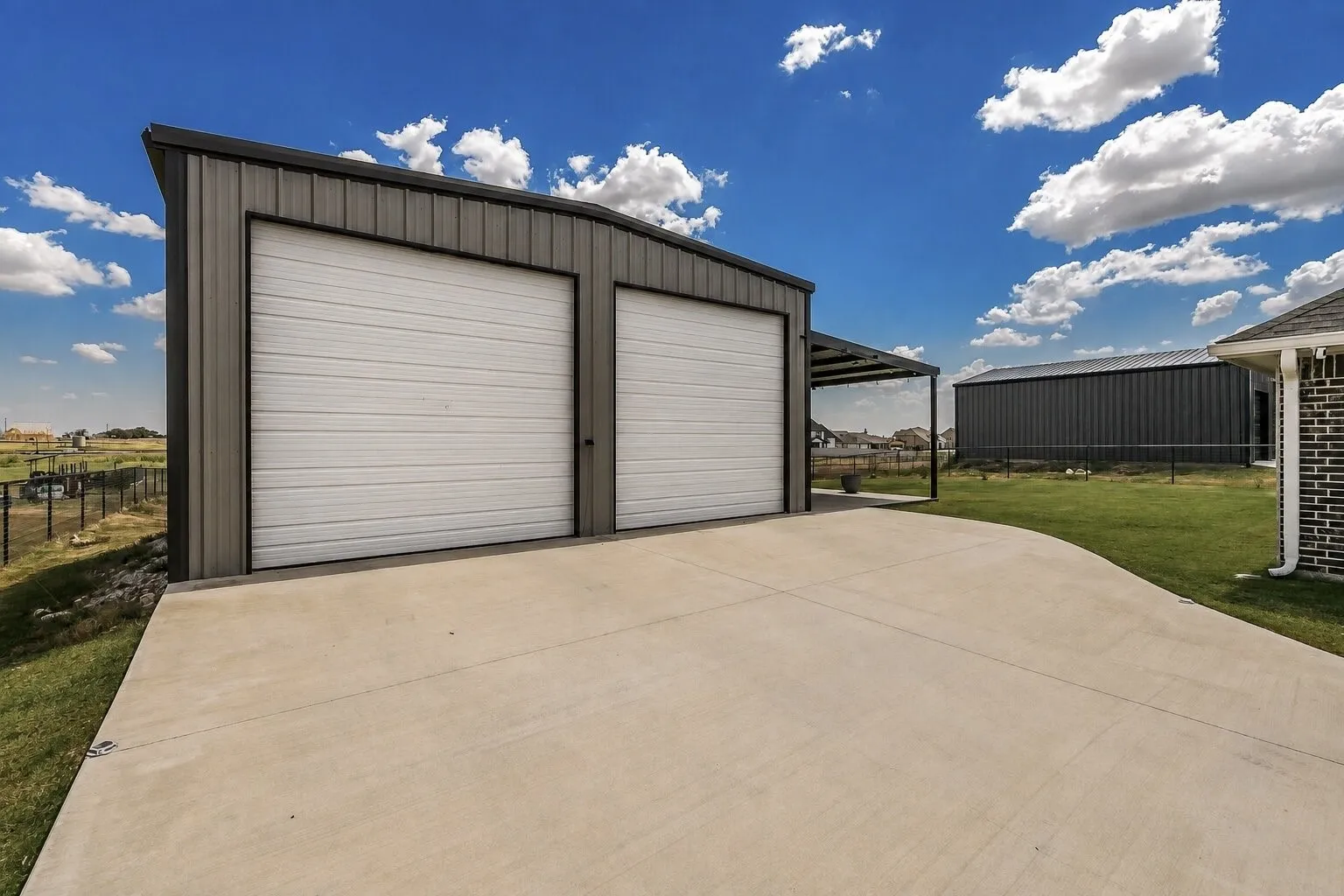 Two-bay metal outbuilding with a single-slope roof and extended covered parking