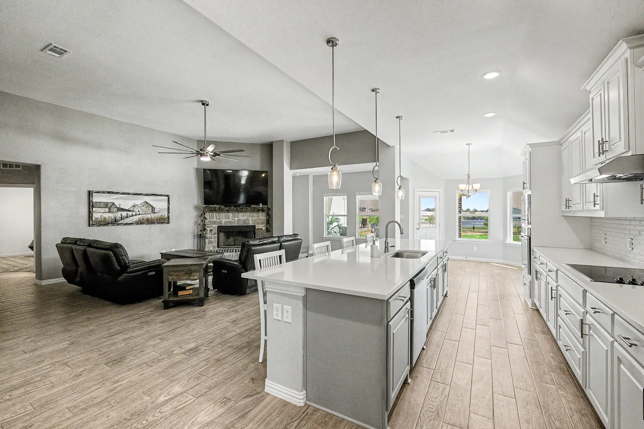Expansive kitchen island with a built-in sink, pendant lighting, and white countertops