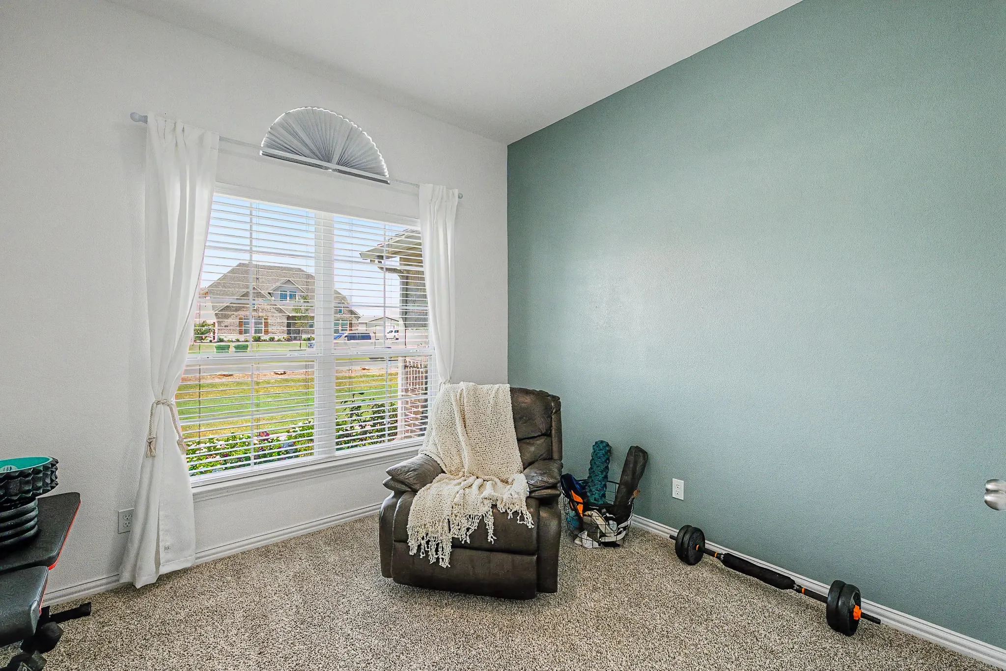 Expansive window with arched transom, white blinds, and sheer white curtains