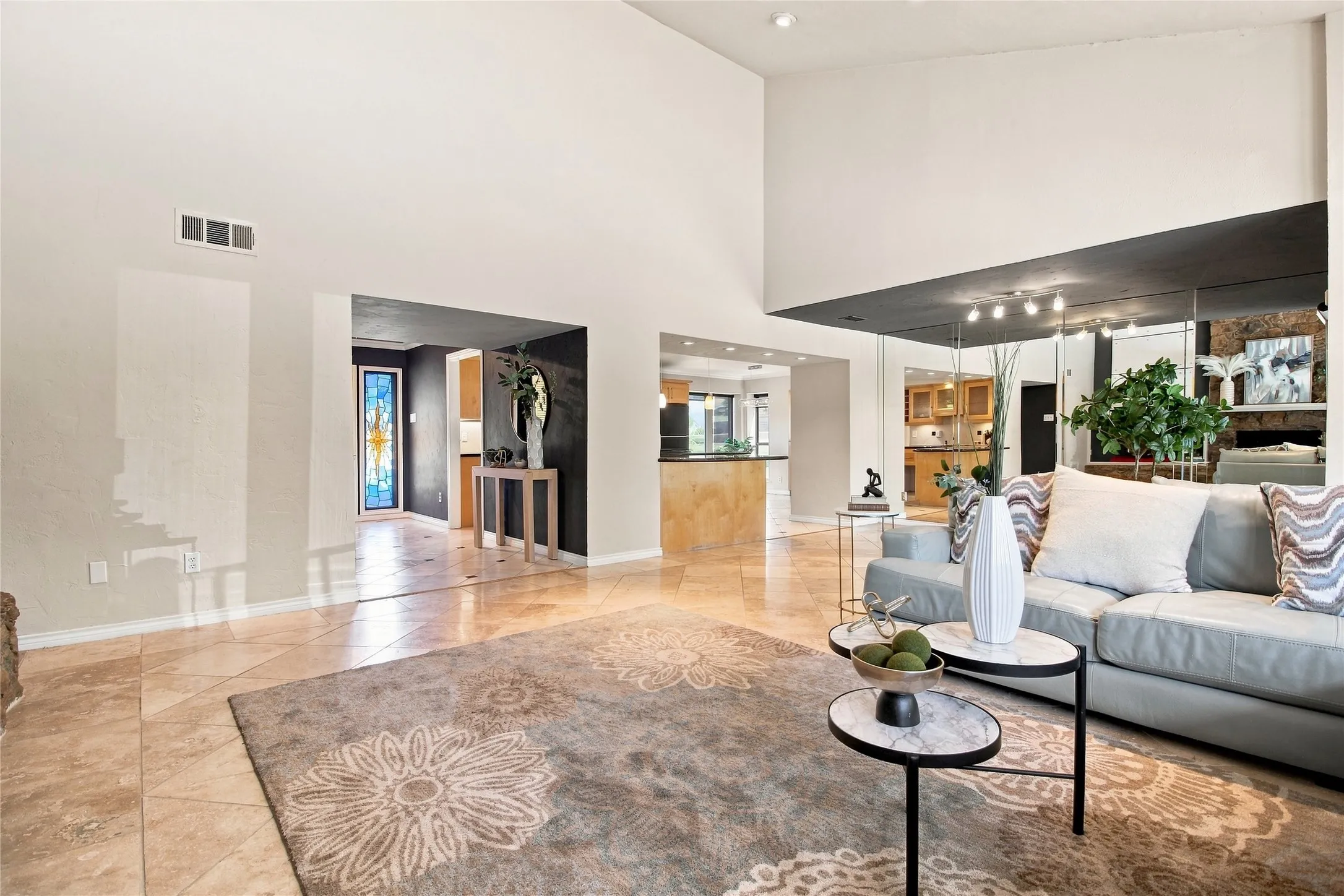 Vaulted ceiling, recessed lighting, tile flooring, mirrored wall, and open archways