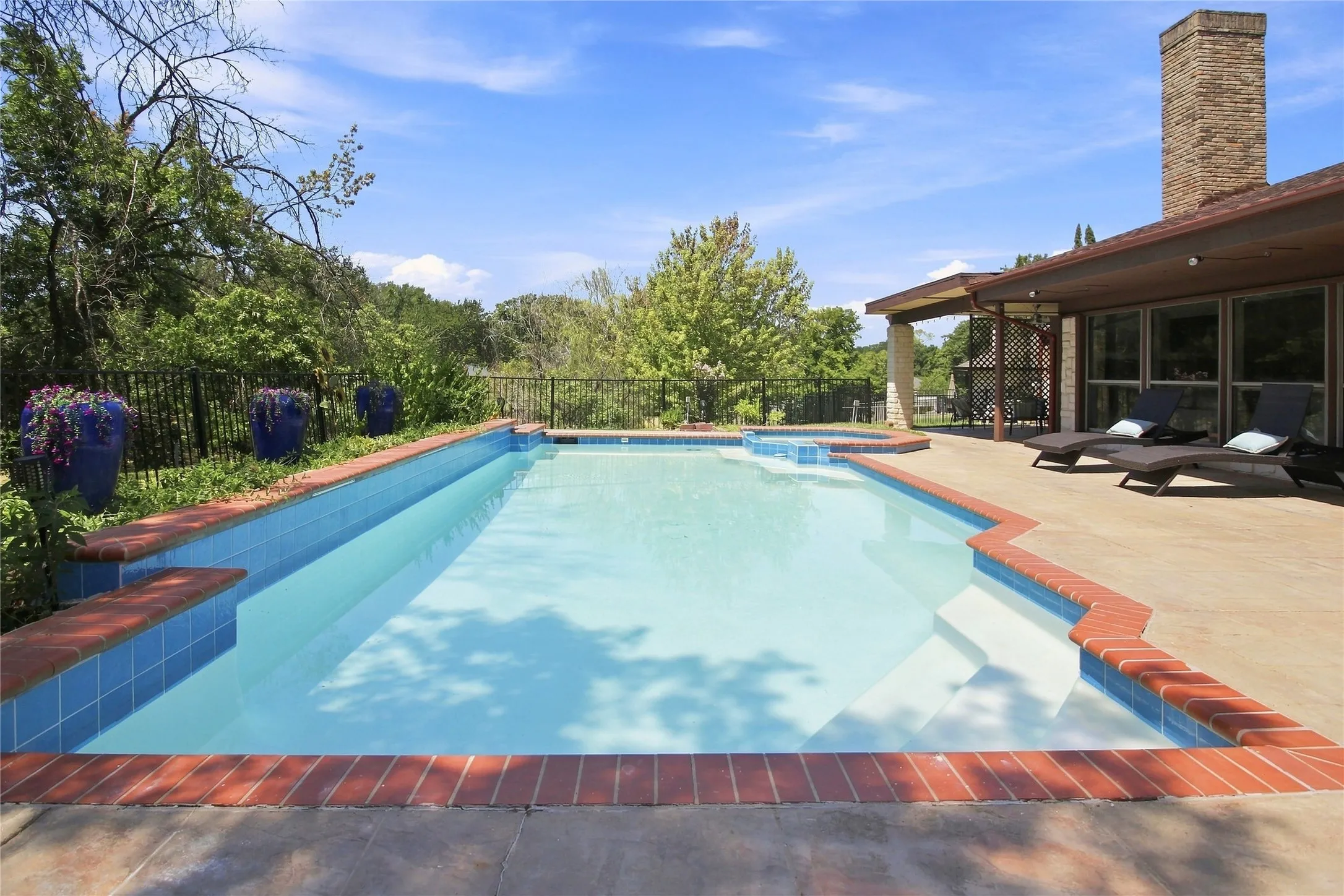 Outdoor swimming pool with integrated spa and concrete decking