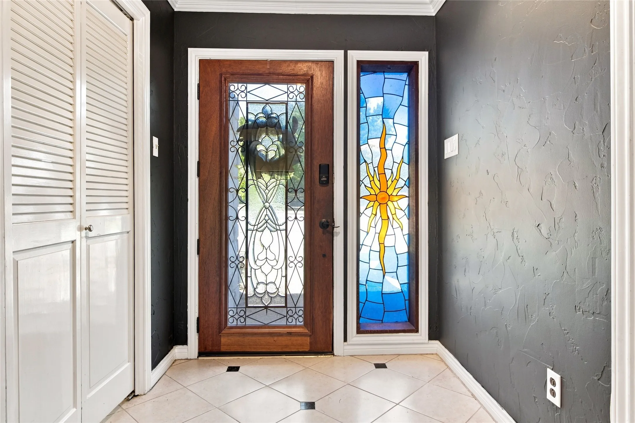 Wood-finish entry door with decorative glass inserts and sidelight