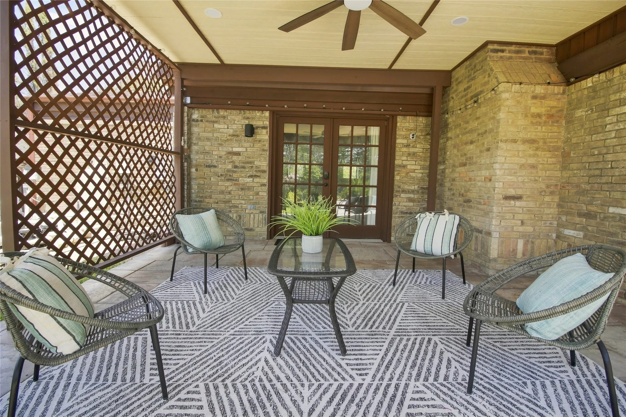 Backyard covered patio with ceiling fan, wall, and swimming pool