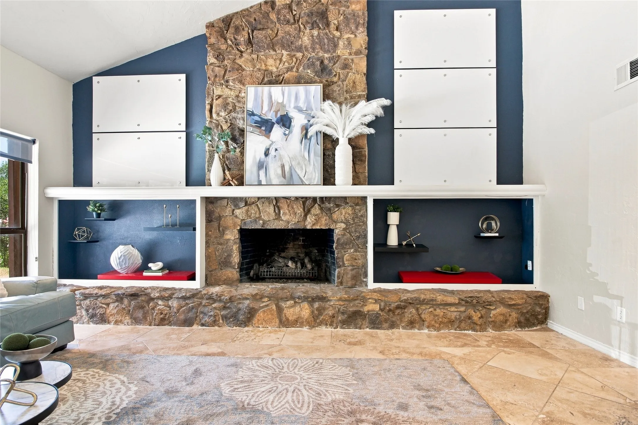 Stone fireplace featuring a deep mantle with built-in shelving, a raised hearth, and stone-finish flooring