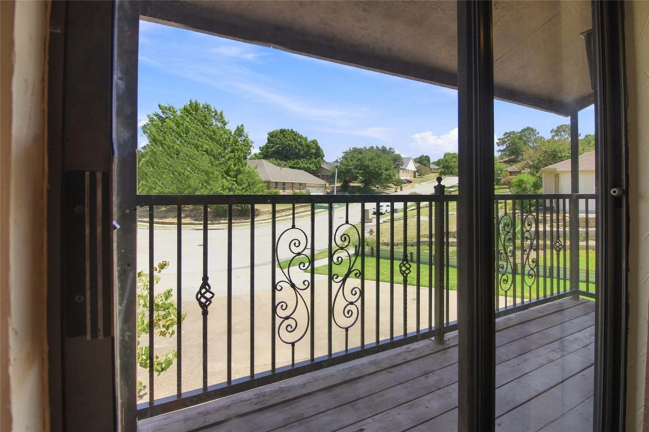Balcony with wood-finish decking and decorative wrought iron railing
