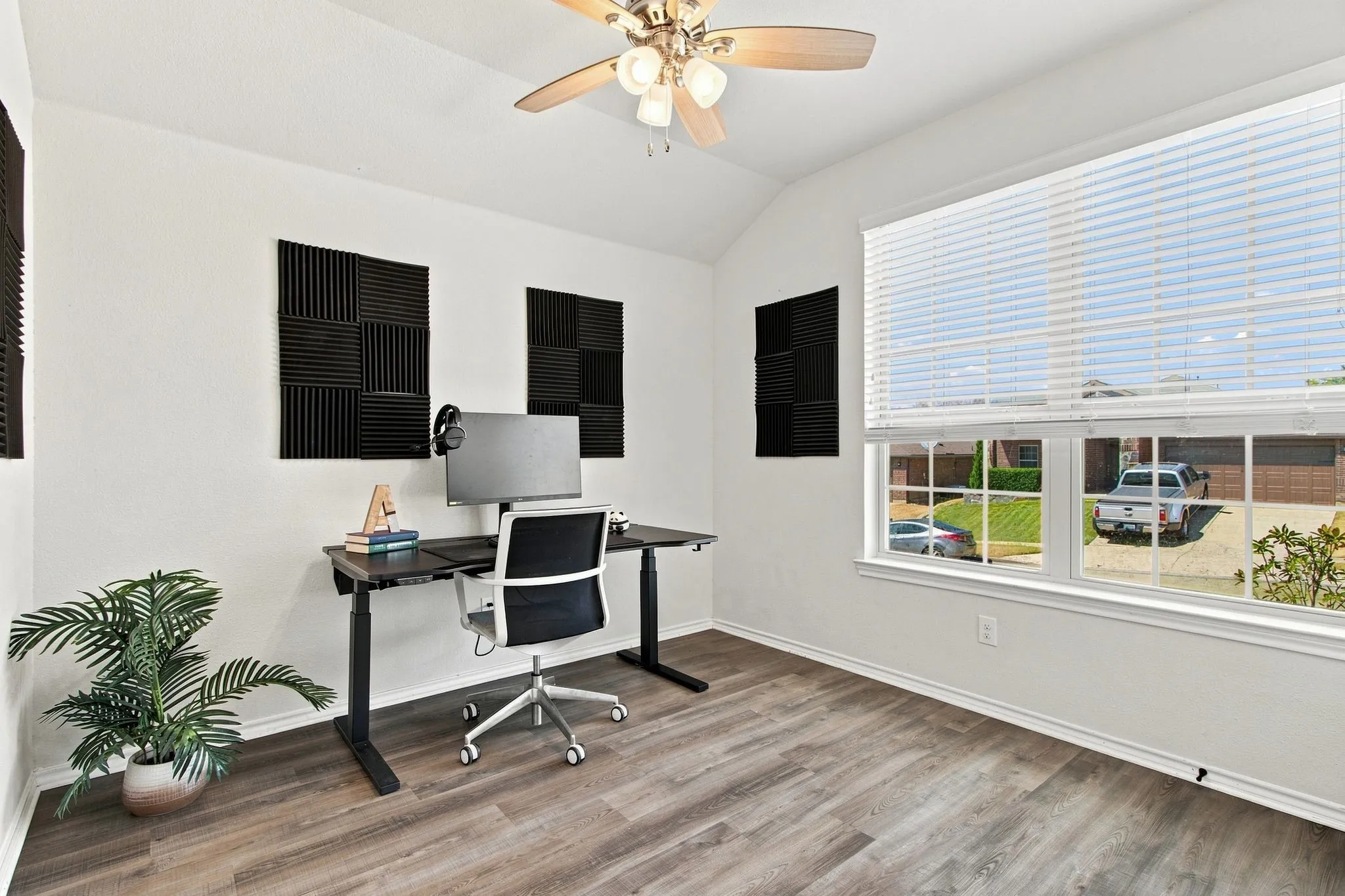Vaulted ceiling, wood-look LVP flooring, ceiling fan, and large windows with blinds. This study could also be used as the 4th bedroom.