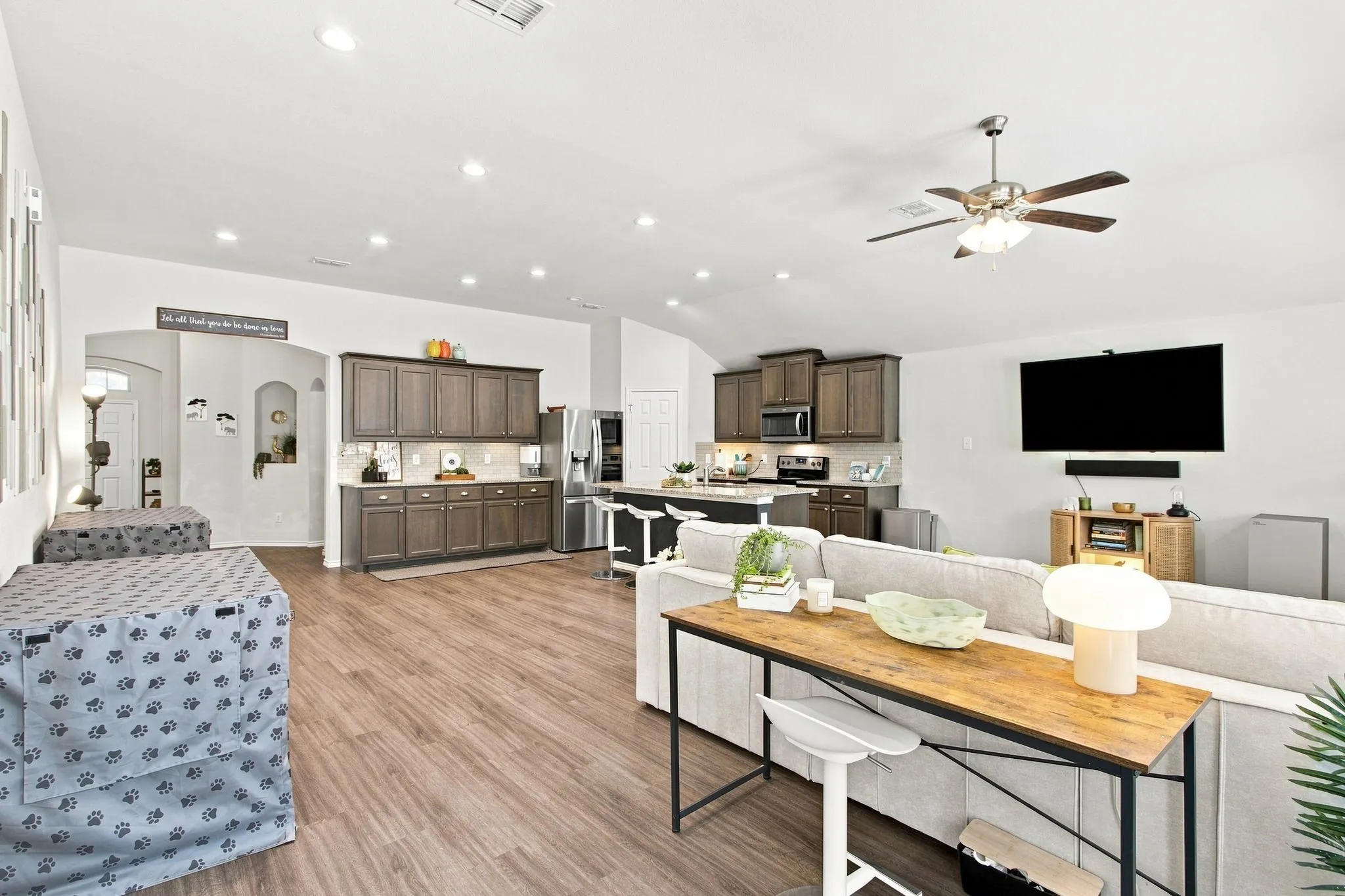 Open-concept living area with wood-finish LVP flooring, recessed lighting, and a ceiling fan. Plenty of space for a dining table and hutch