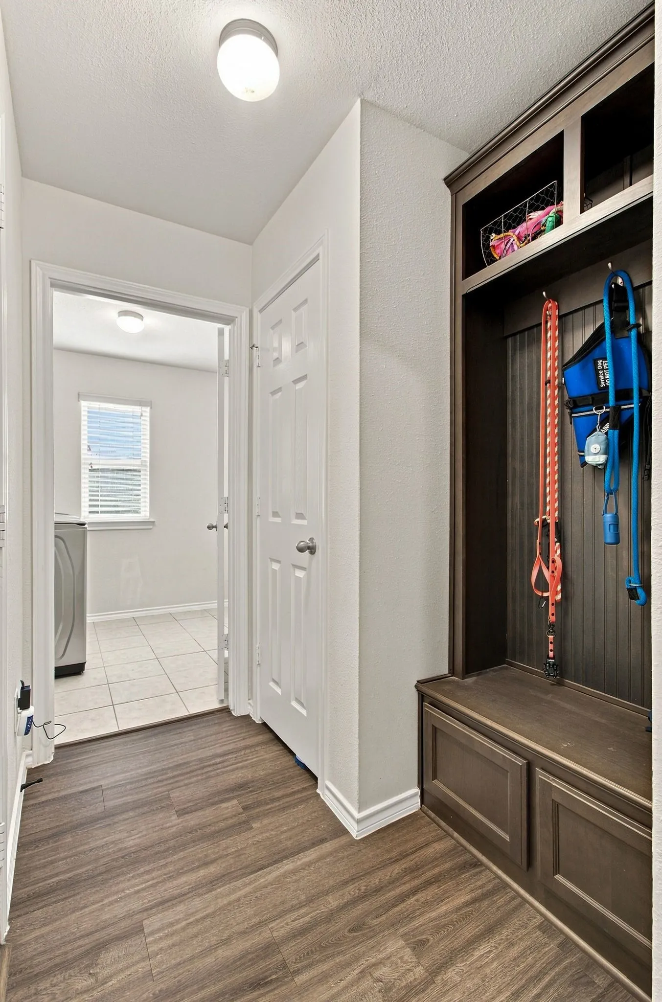 Built-in storage bench with overhead shelving, wood-finish LVP flooring, and recessed ceiling lighting (mud room)