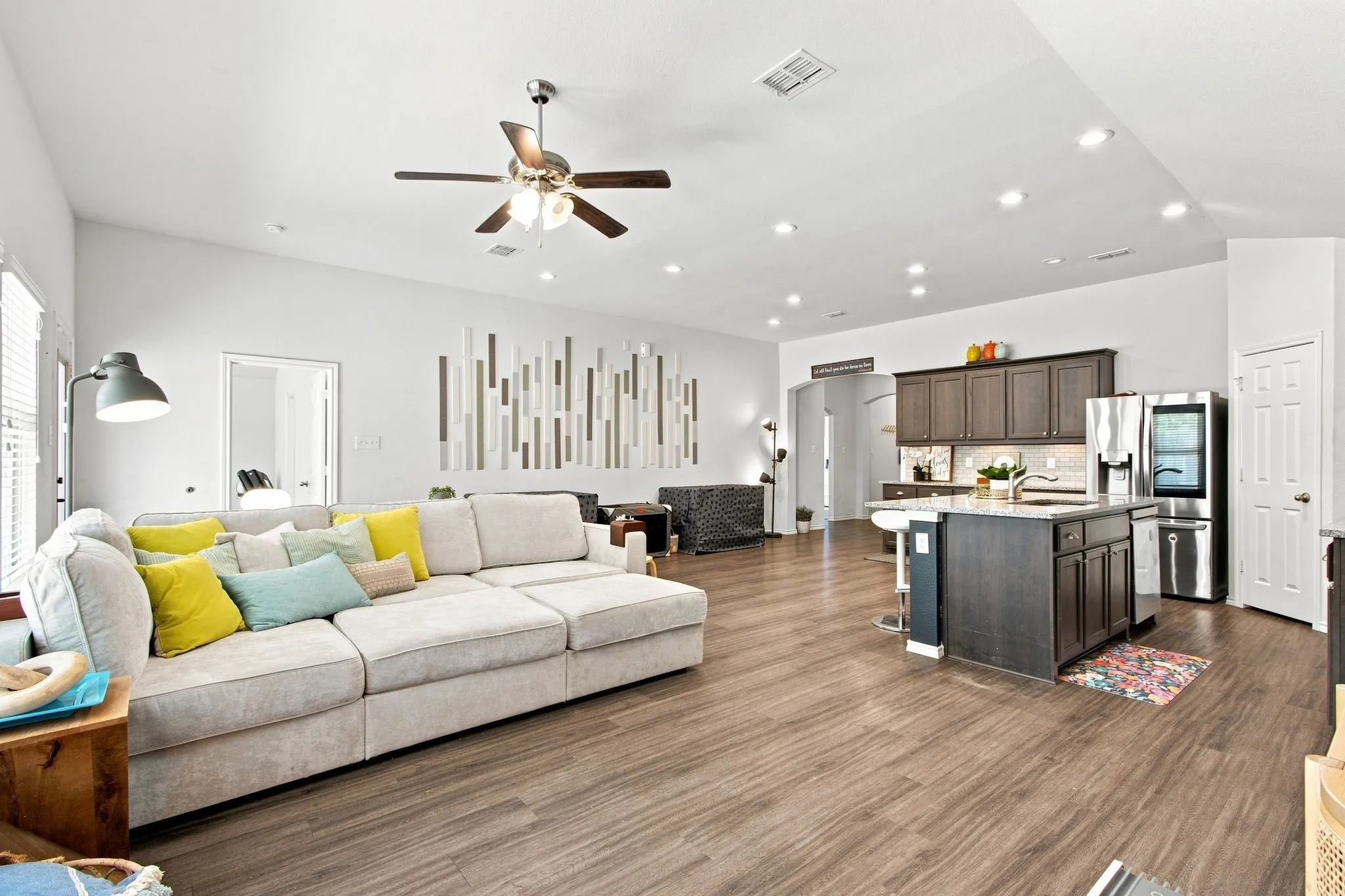 Open-concept living & Kitchen area featuring wood-finish LVP flooring, recessed lighting, and a ceiling fan