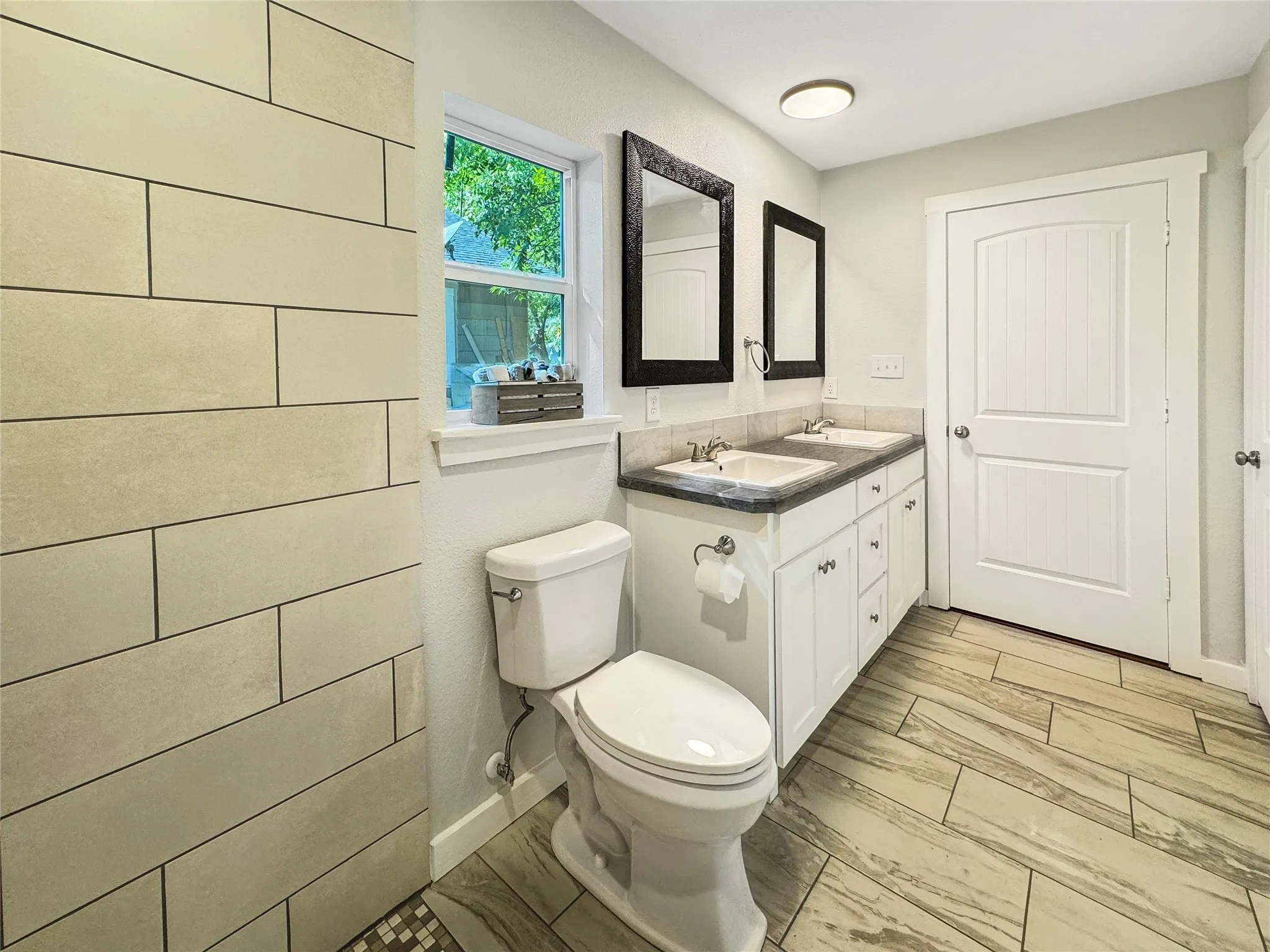 Primary Bathroom features Dual basin vanity with undermount sinks and dark countertops