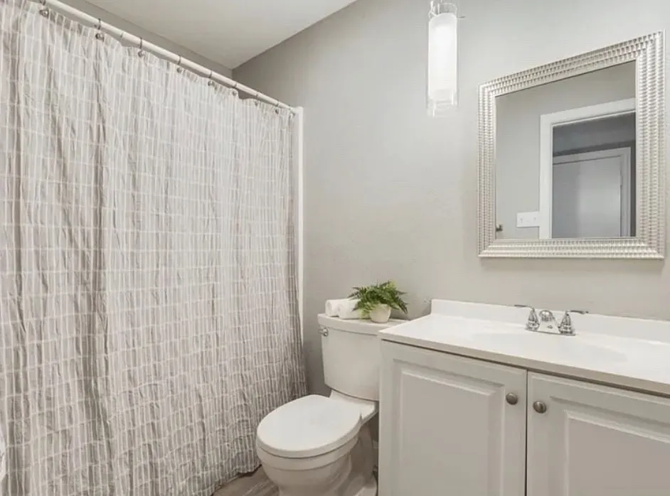 White vanity with integrated sink, chrome faucet, and framed mirror