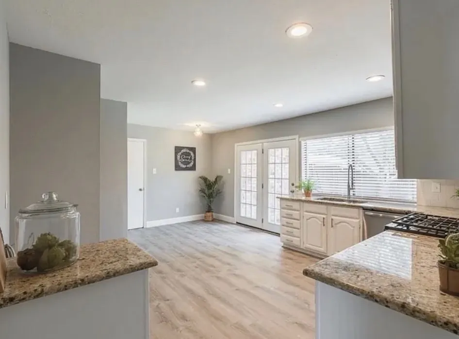 Granite countertops, white cabinetry, stainless steel appliances, wood-finish flooring, and recessed lighting