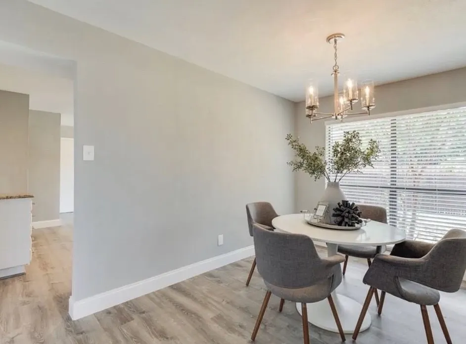 Wood-finish flooring throughout, complemented by a contemporary chandelier with glass shades