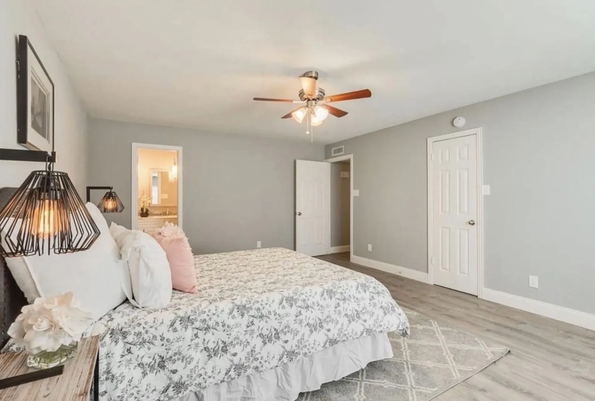 Wood-finish flooring, ceiling fan with integrated lighting, paneled interior doors, and a neutral wall palette