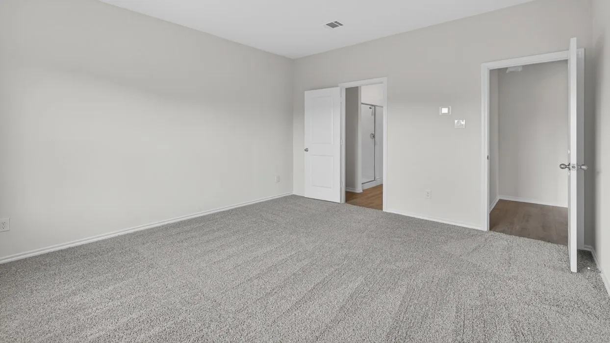 Spacious room featuring light gray walls, gray carpet flooring, and white trim