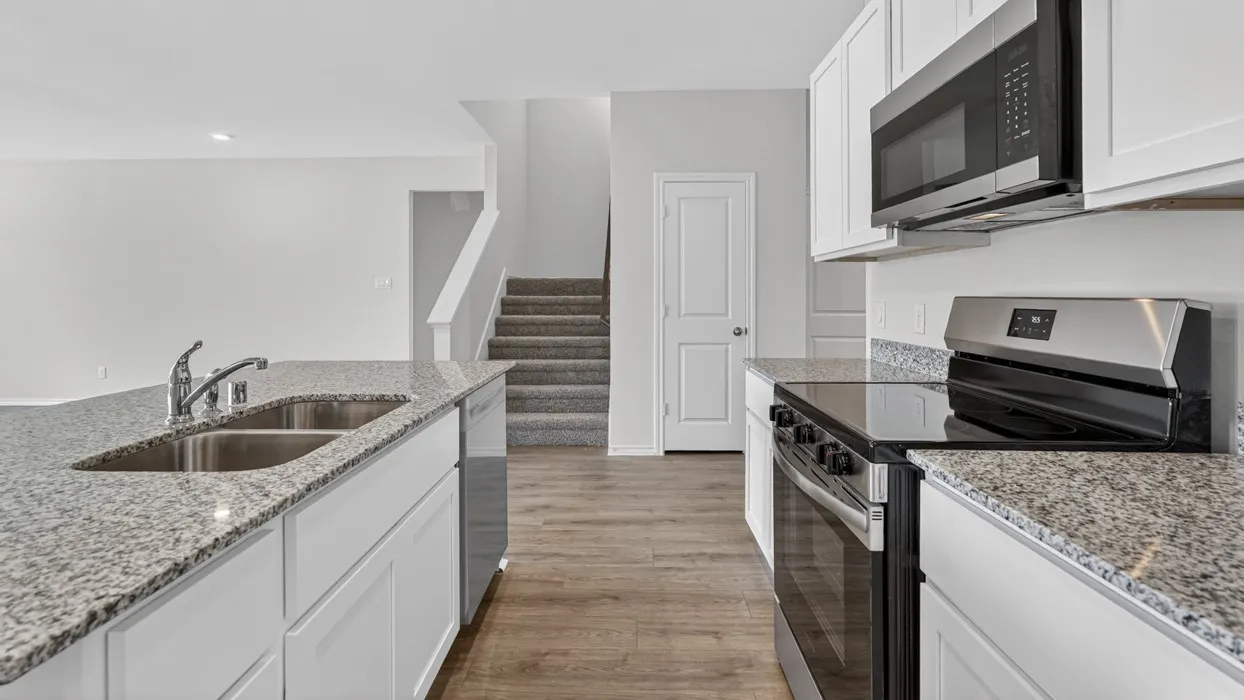 Kitchen featuring white cabinetry, stainless steel appliances, a double basin sink, and wood-finish flooring