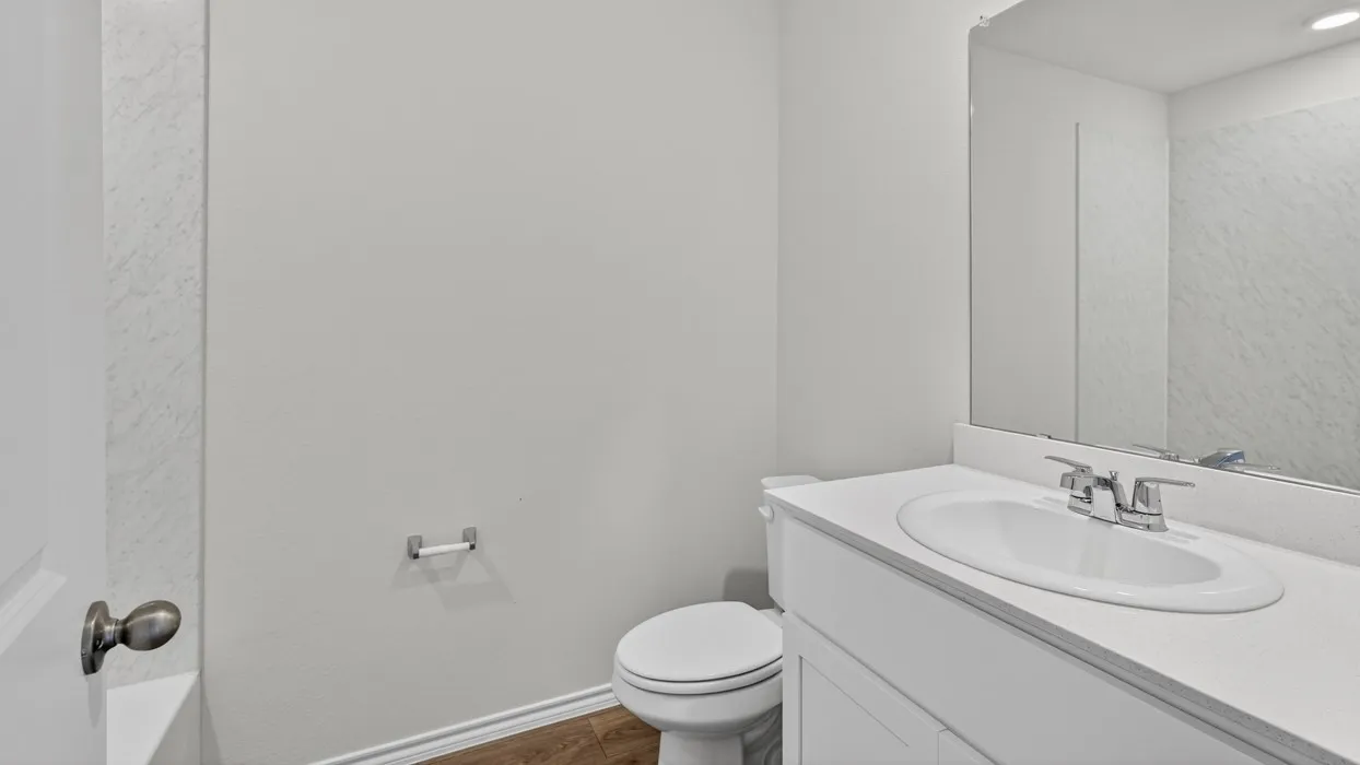 Bathroom vanity with integrated sink, chrome faucet, and expansive mirror