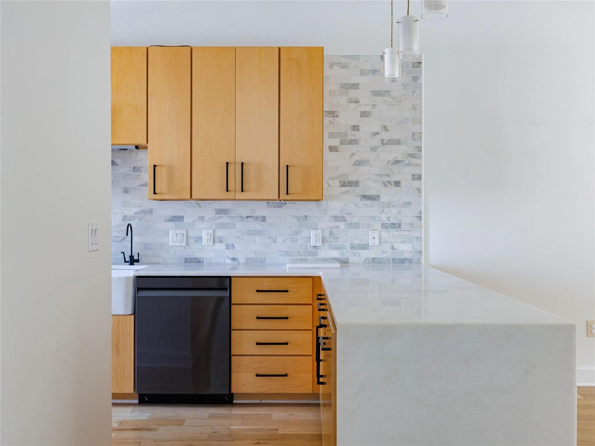 Warm natural wood cabinetry brings depth and character to this bright, contemporary kitchen.