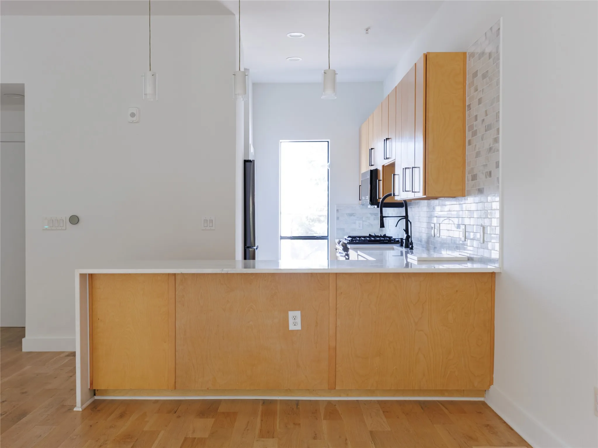 The extended peninsula offers additional preparation space, storage, and casual bar seating.