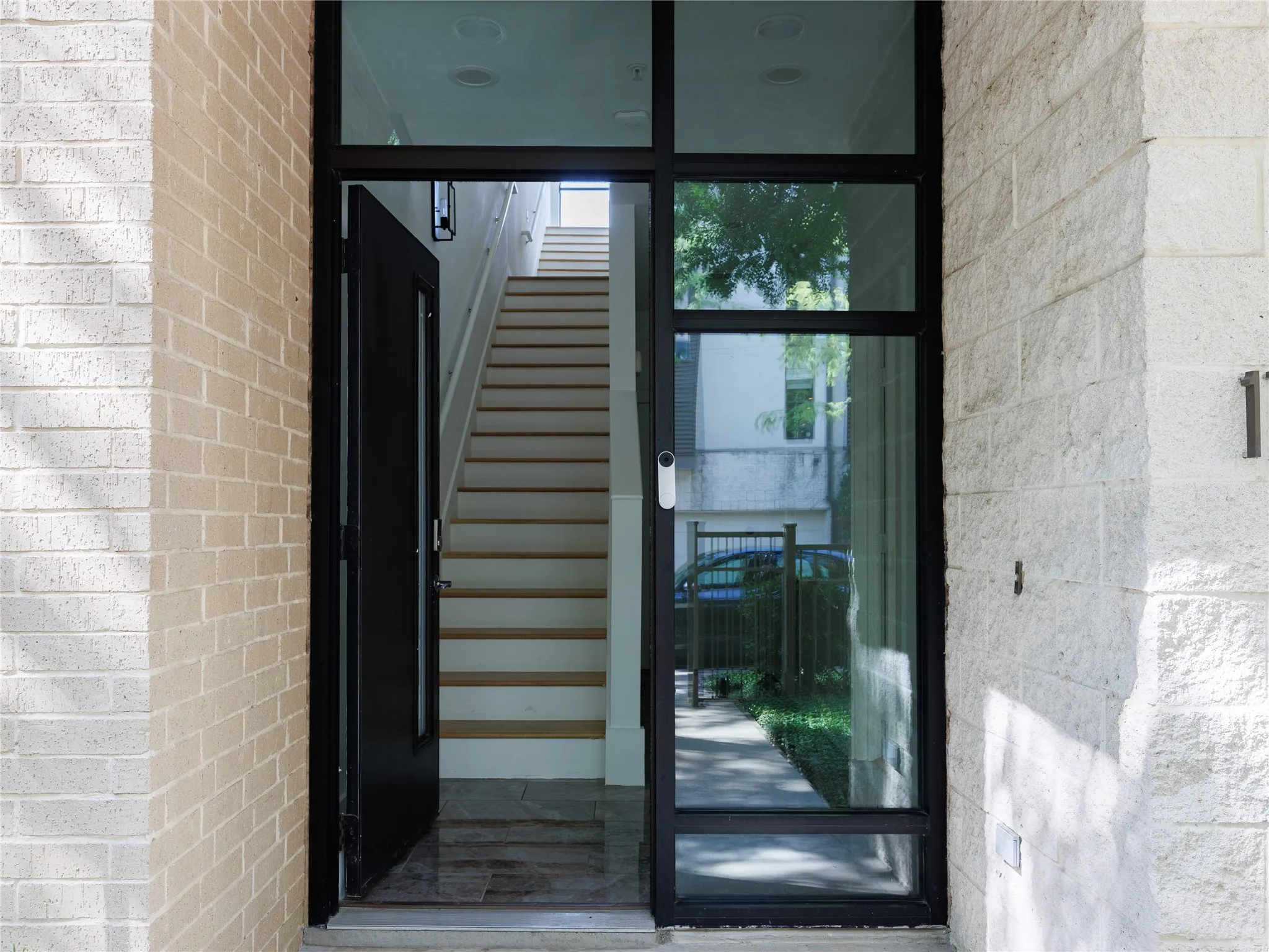 Dramatic glass-framed entry introduces the home with clean lines and abundant natural light.