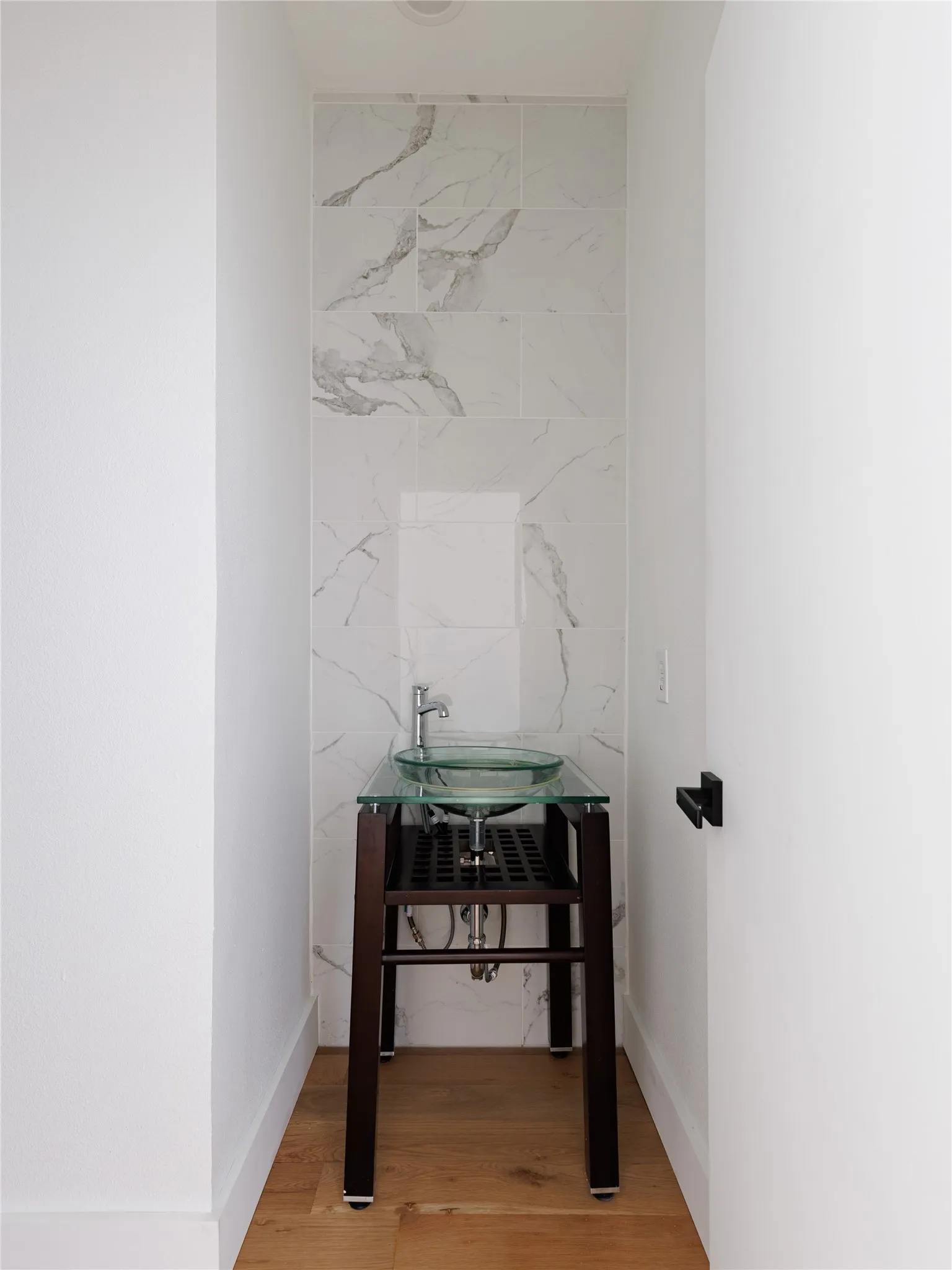 Conveniently located half bathroom with contemporary finishes, clean lines, and a functional layout for guests.