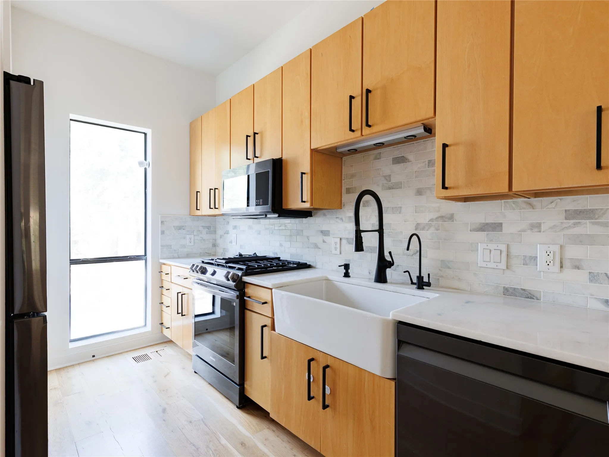 A gas range, full-height cabinetry, and stainless steel appliances support an efficient cooking layout.