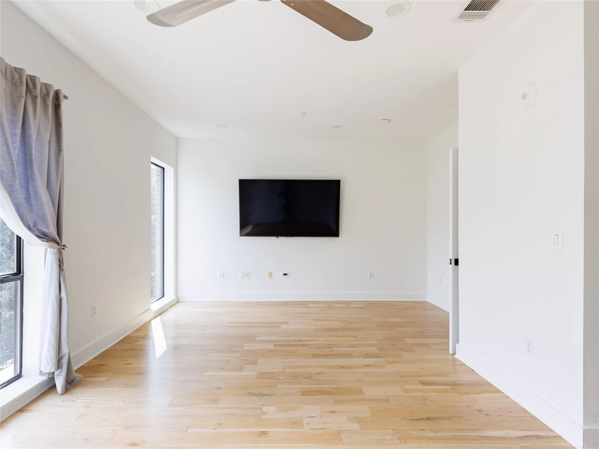 Generously sized bedroom with tall ceilings, clean contemporary finishes, and ample space for additional furniture.