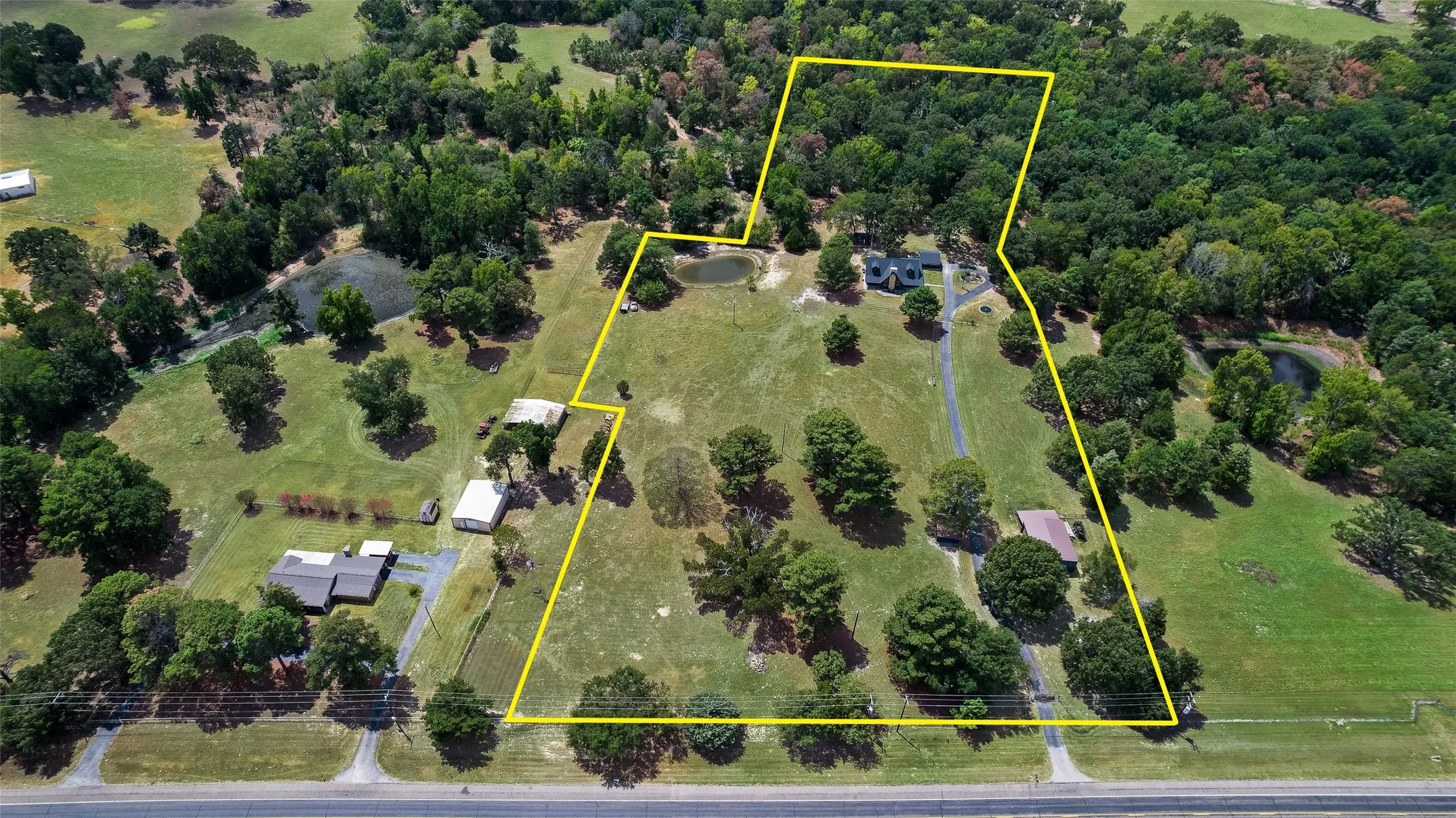 7.28 acres fully fenced property with shop, pond, above ground pool, chicken coop, in ground trampoline, and creek at back of property