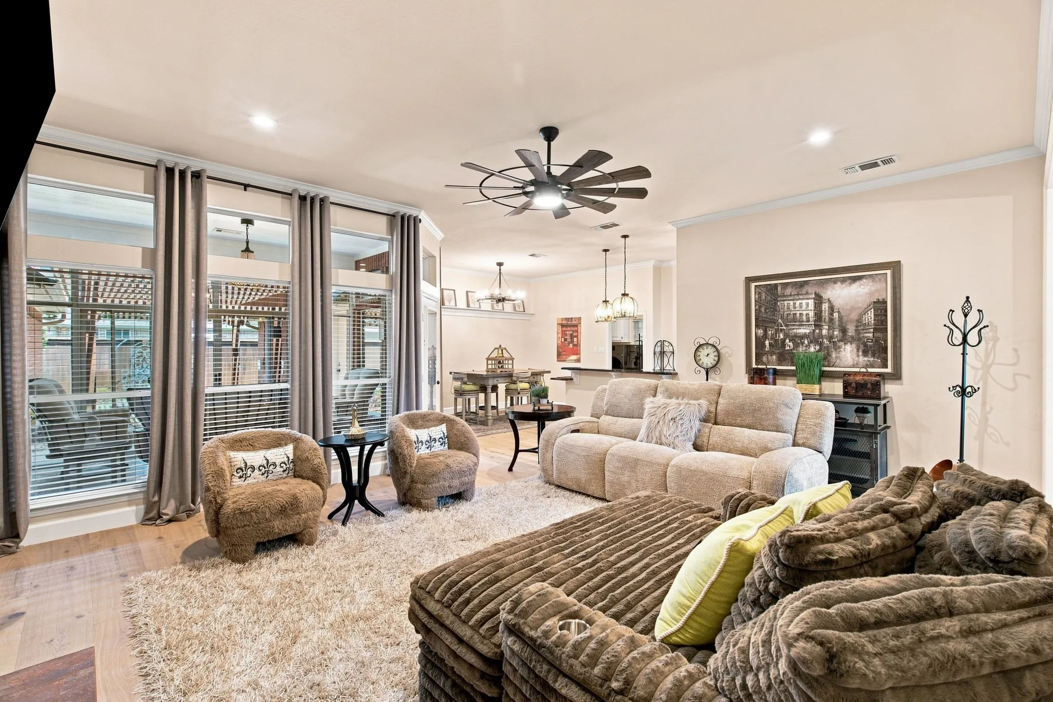 Expansive living area featuring light wood-finish flooring, recessed lighting, and a multi-blade ceiling fan