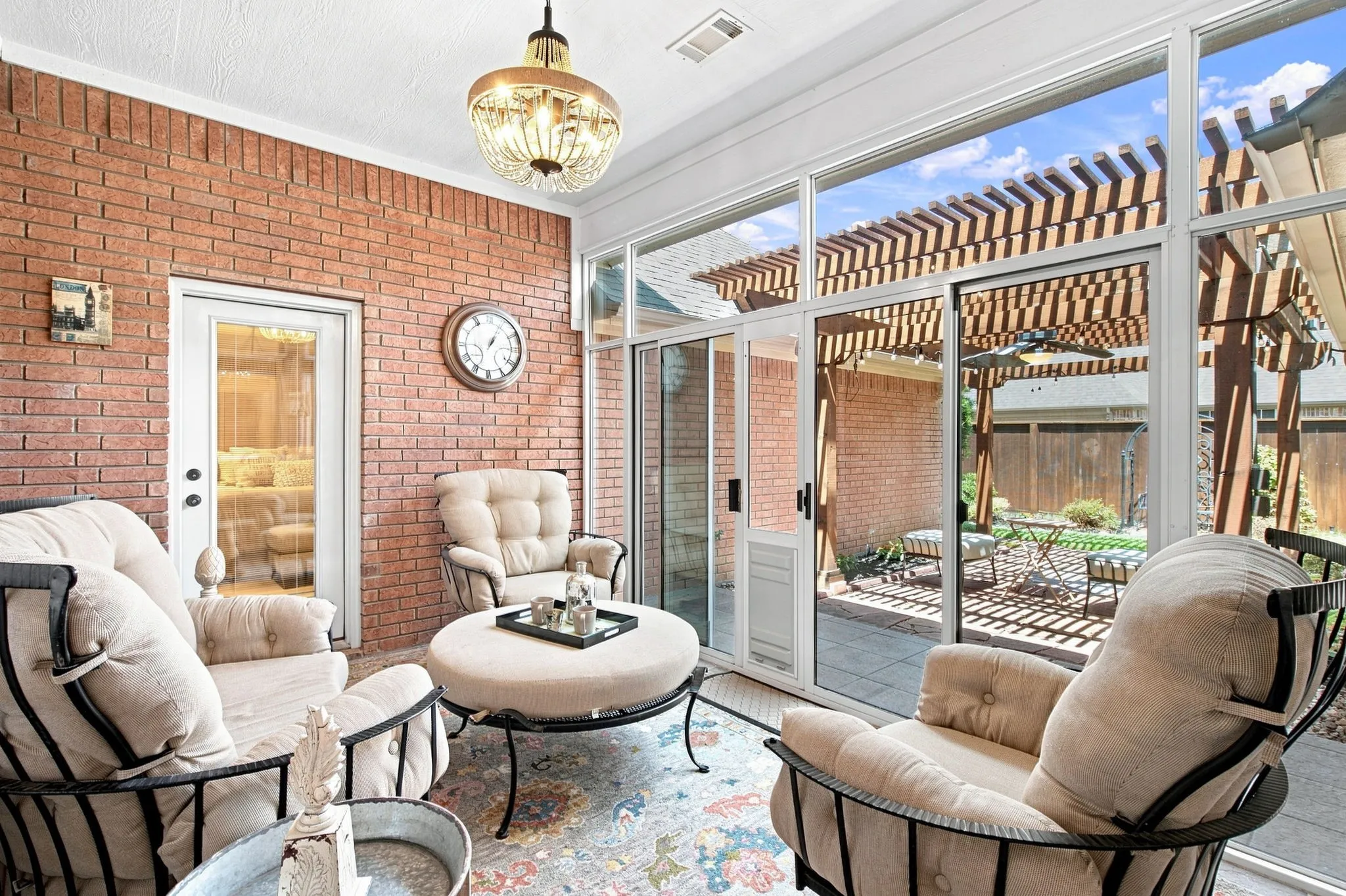 Sunroom with brick wall, glass panel walls, and a decorative ceiling light fixture