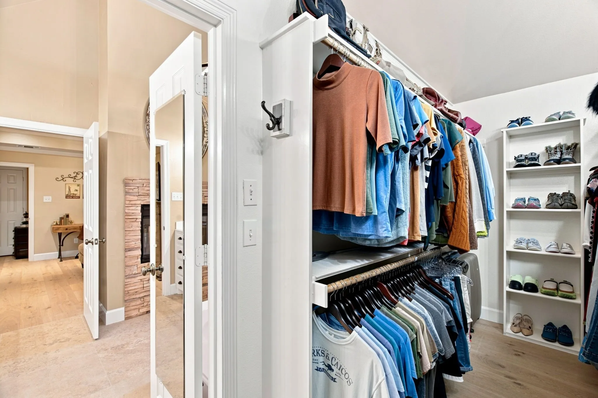 Custom closet system featuring multiple hanging rods, integrated shelving, and white wood-finish built-ins
