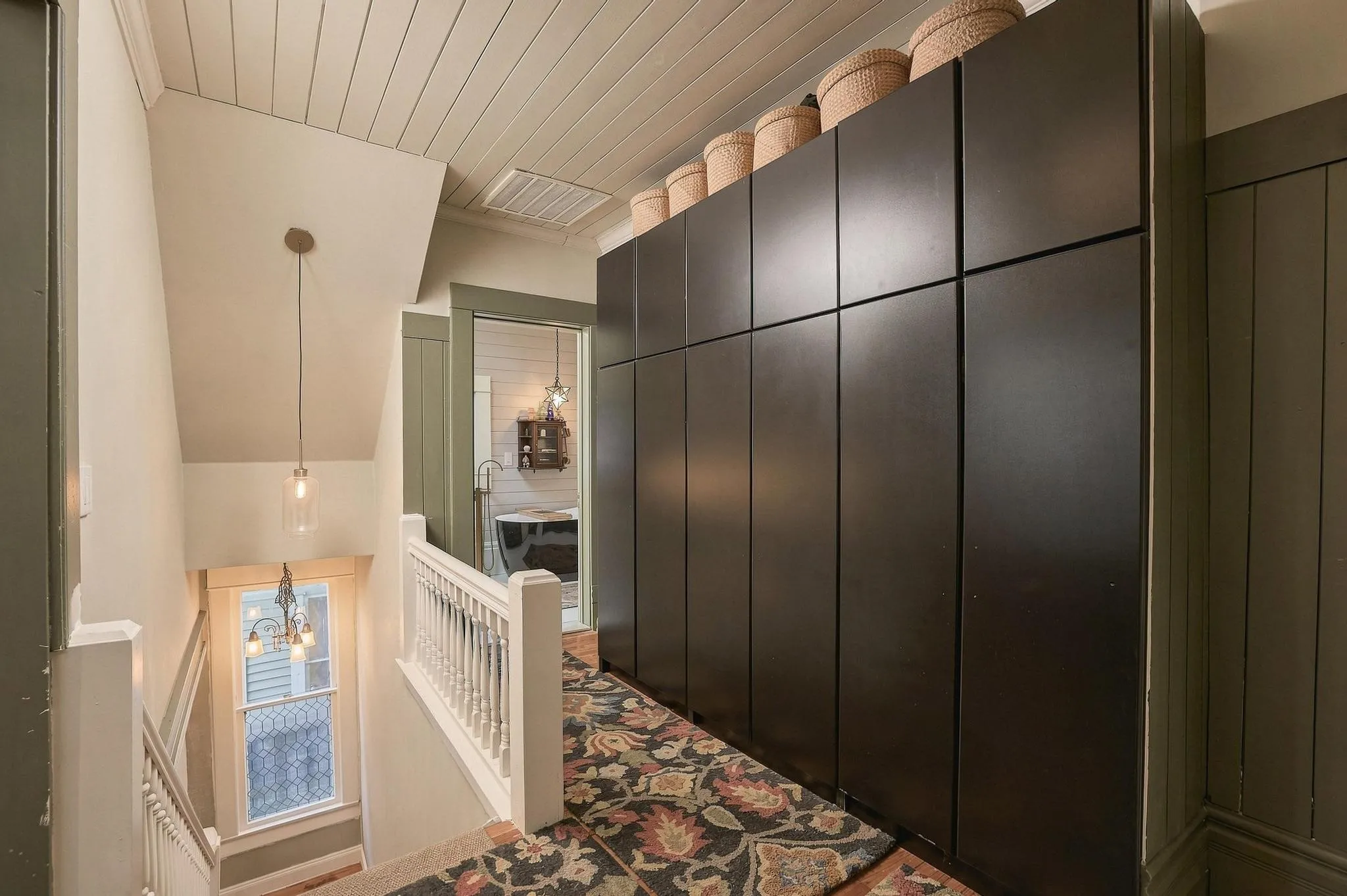 This space pairs contemporary storage and modern lighting with historic plank ceiling and the original staircase.