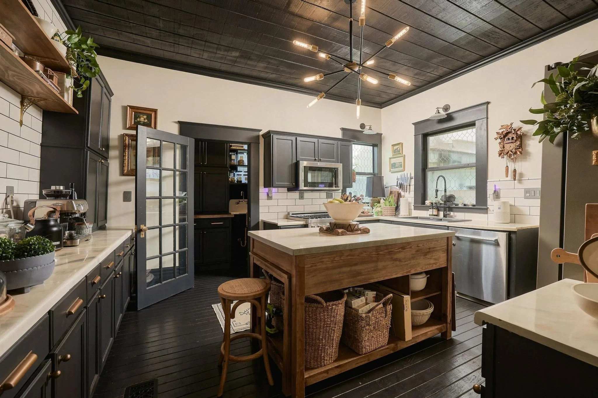 The modernized kitchen showcases an eye-catching plank ceiling, natural wood center island and seamless access to a butler's pantry.