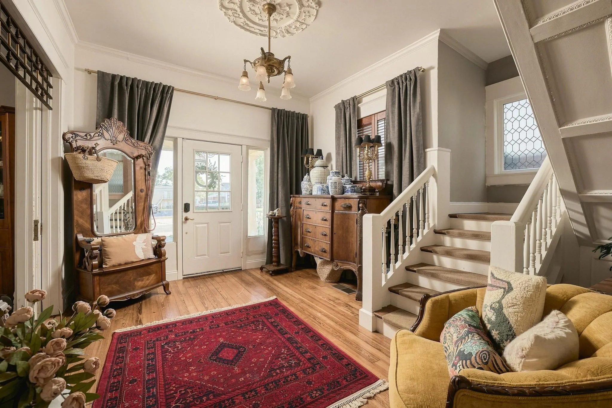 The Entry is Graced with a Period Correct Gilded Chandelier and Ceiling Medallion. The Generous Size of this Space is Ideal for a Sitting Room or Cozy Reading Nook Under the Stairs.