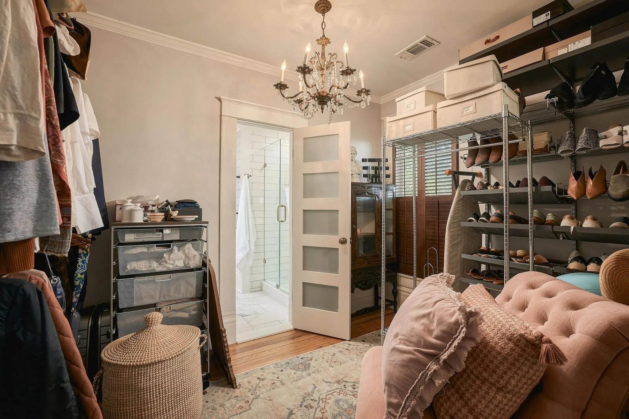 The generously sized dressing room boasts a period-correct crystal chandelier, ample storage capacity and even room for a chair!