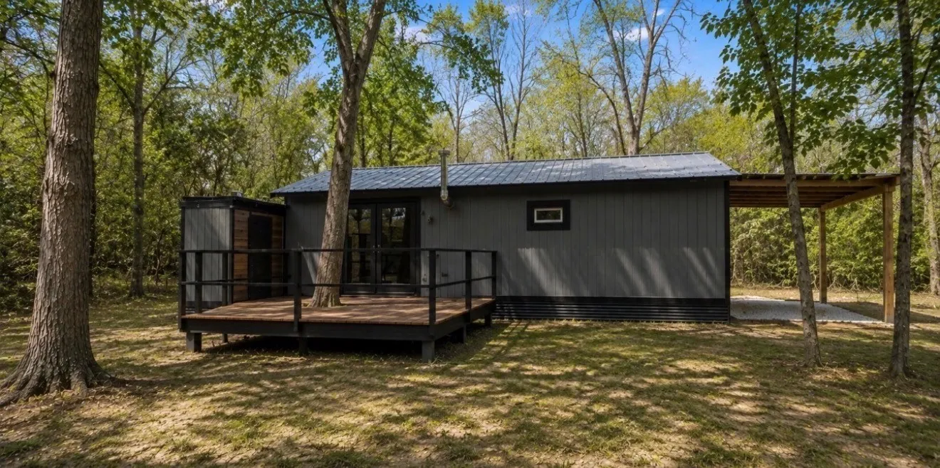 Exterior featuring board and batten siding, a metal roof, and an elevated wood deck with black railings