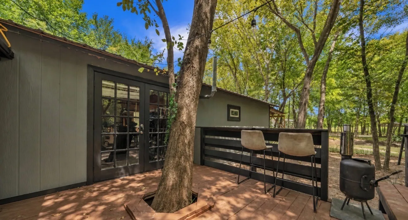 Expansive outdoor deck featuring wood-finish flooring, built-in bar, and direct access through double glass panel doors